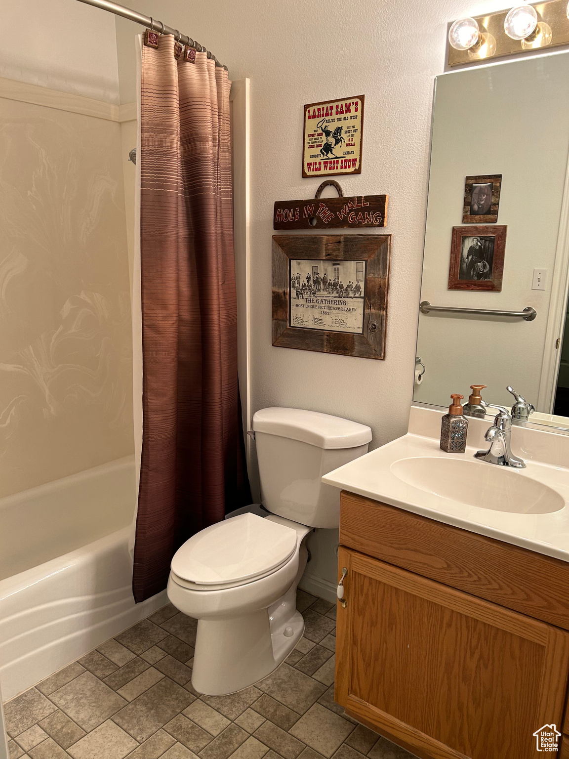 Full bathroom with shower / tub combo with curtain, large vanity, tile floors, and toilet