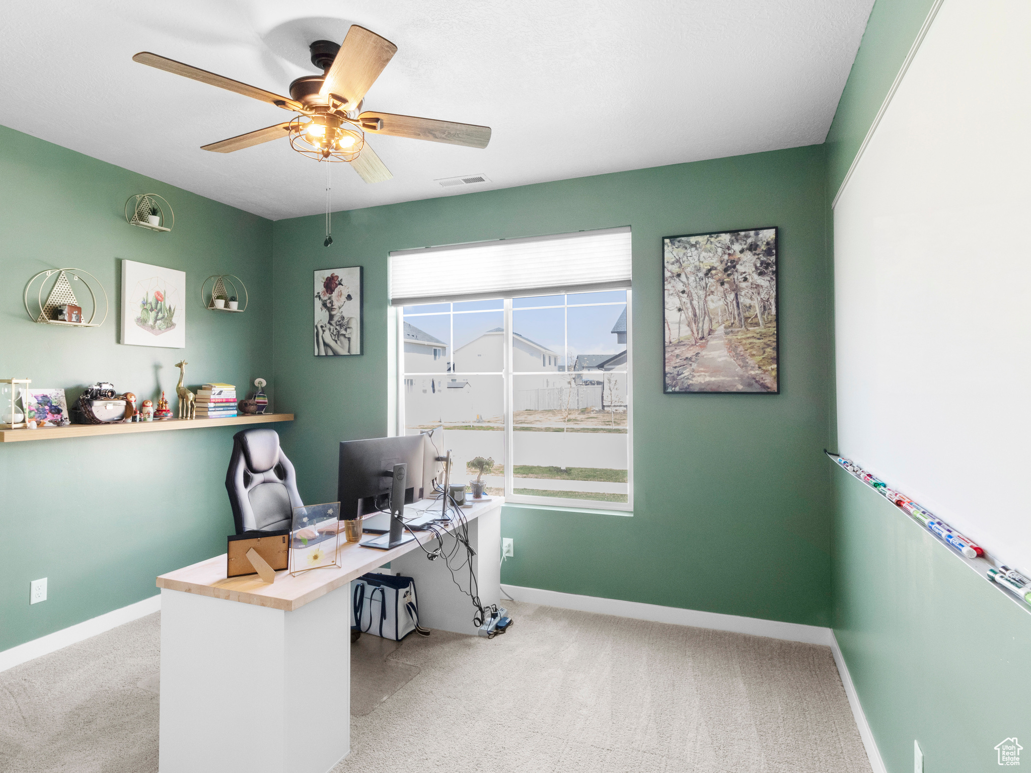 Carpeted office space featuring ceiling fan
