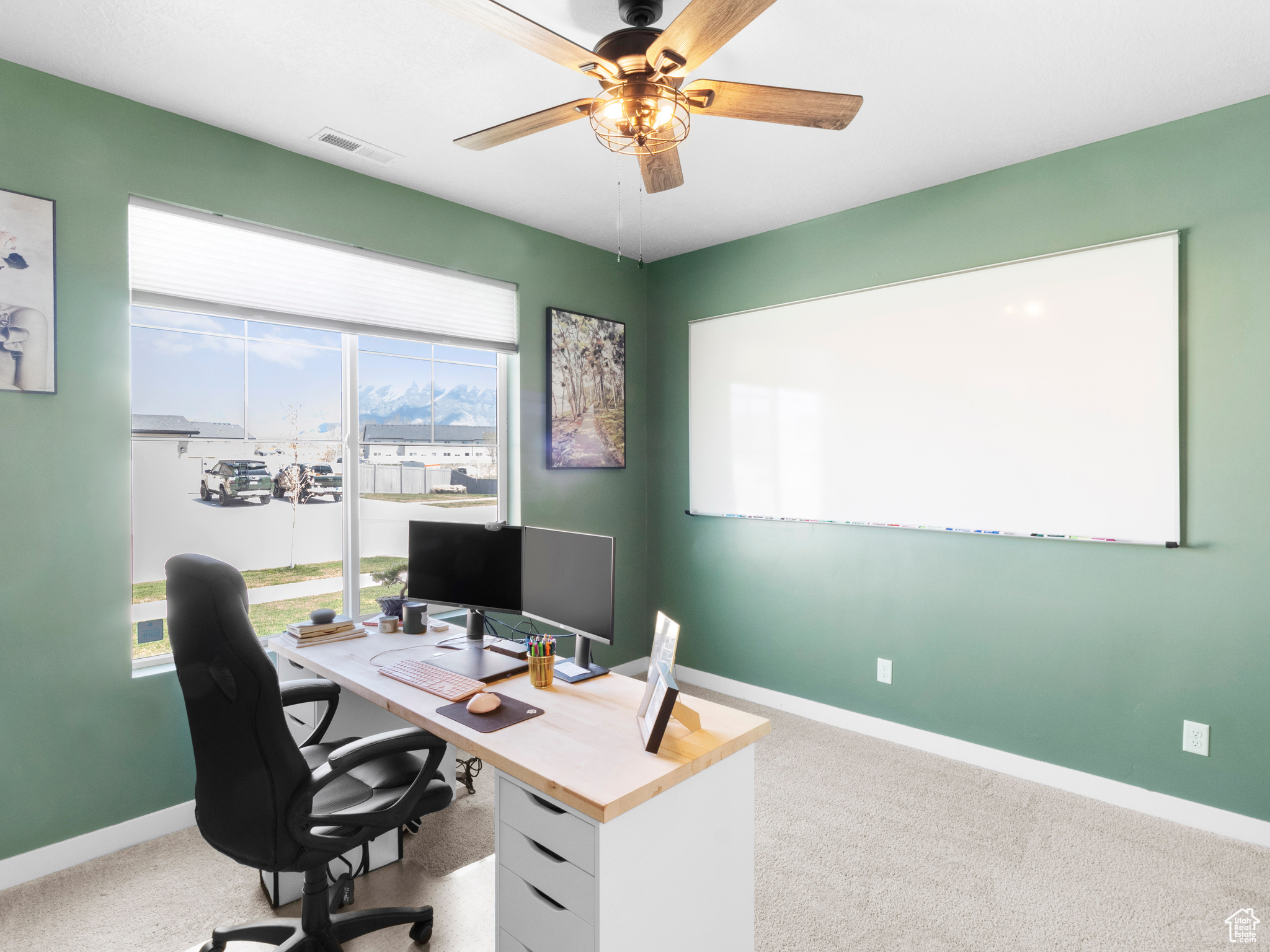 Carpeted office space with ceiling fan