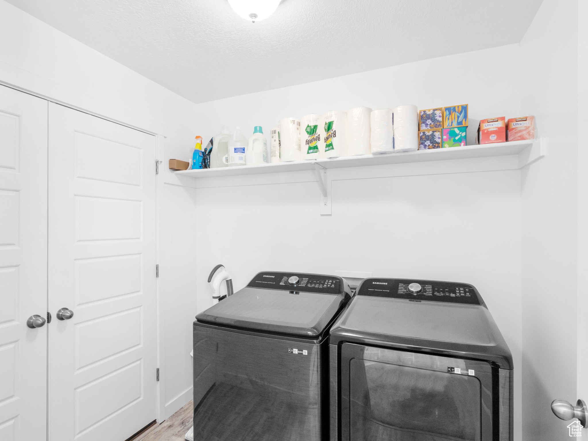 Laundry area with independent washer and dryer, hookup for a washing machine, and hardwood / wood-style flooring