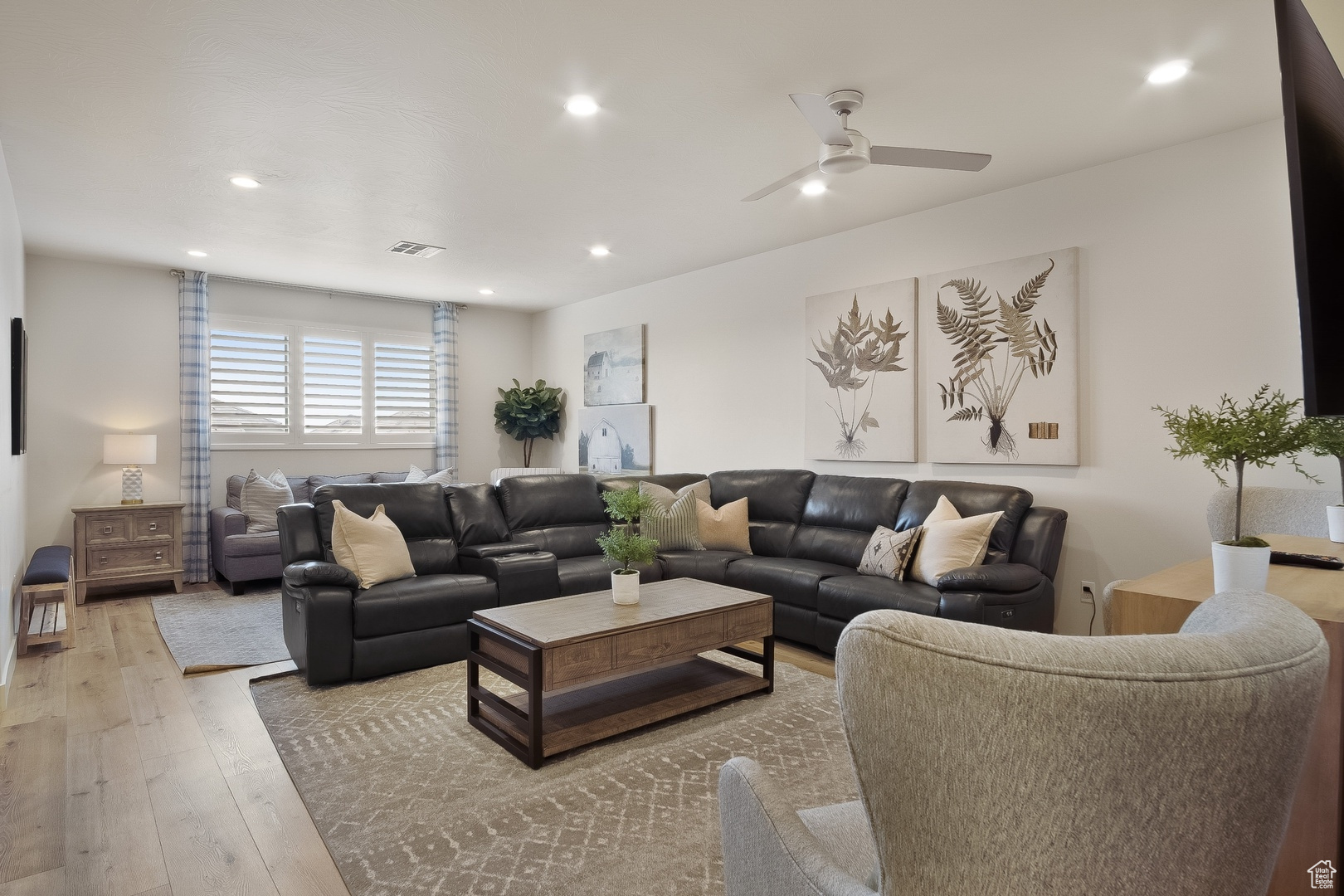 Living room featuring ceiling fan and light hardwood / wood-style floors