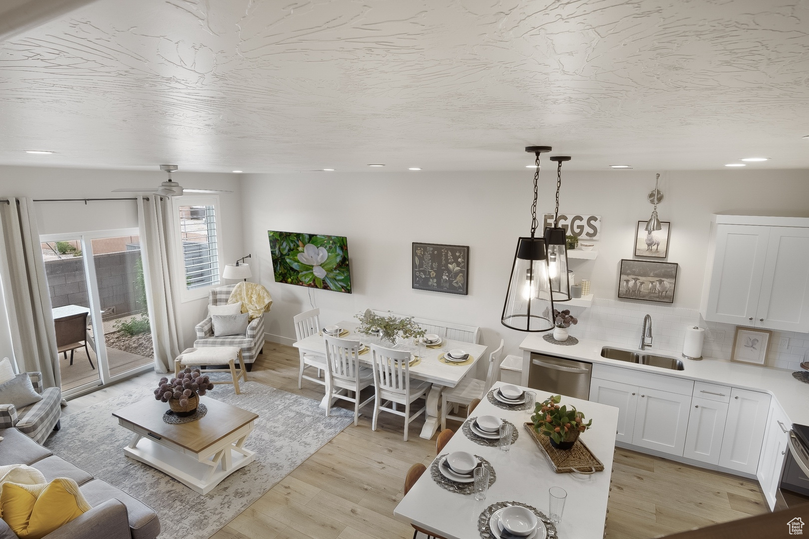 Living room featuring sink, ceiling fan, and light hardwood / wood-style floors