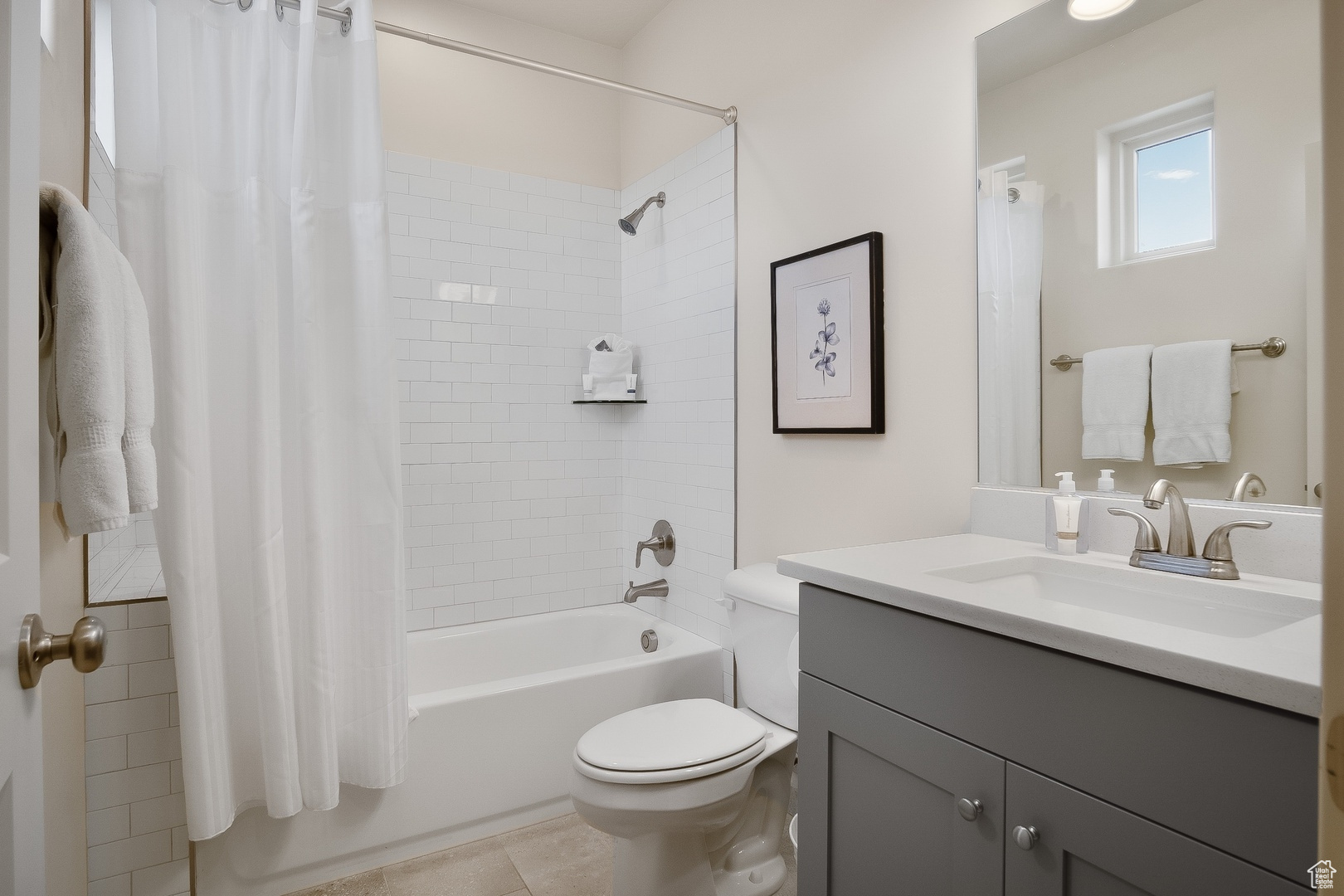 Full bathroom with toilet, oversized vanity, shower / tub combo with curtain, and tile flooring