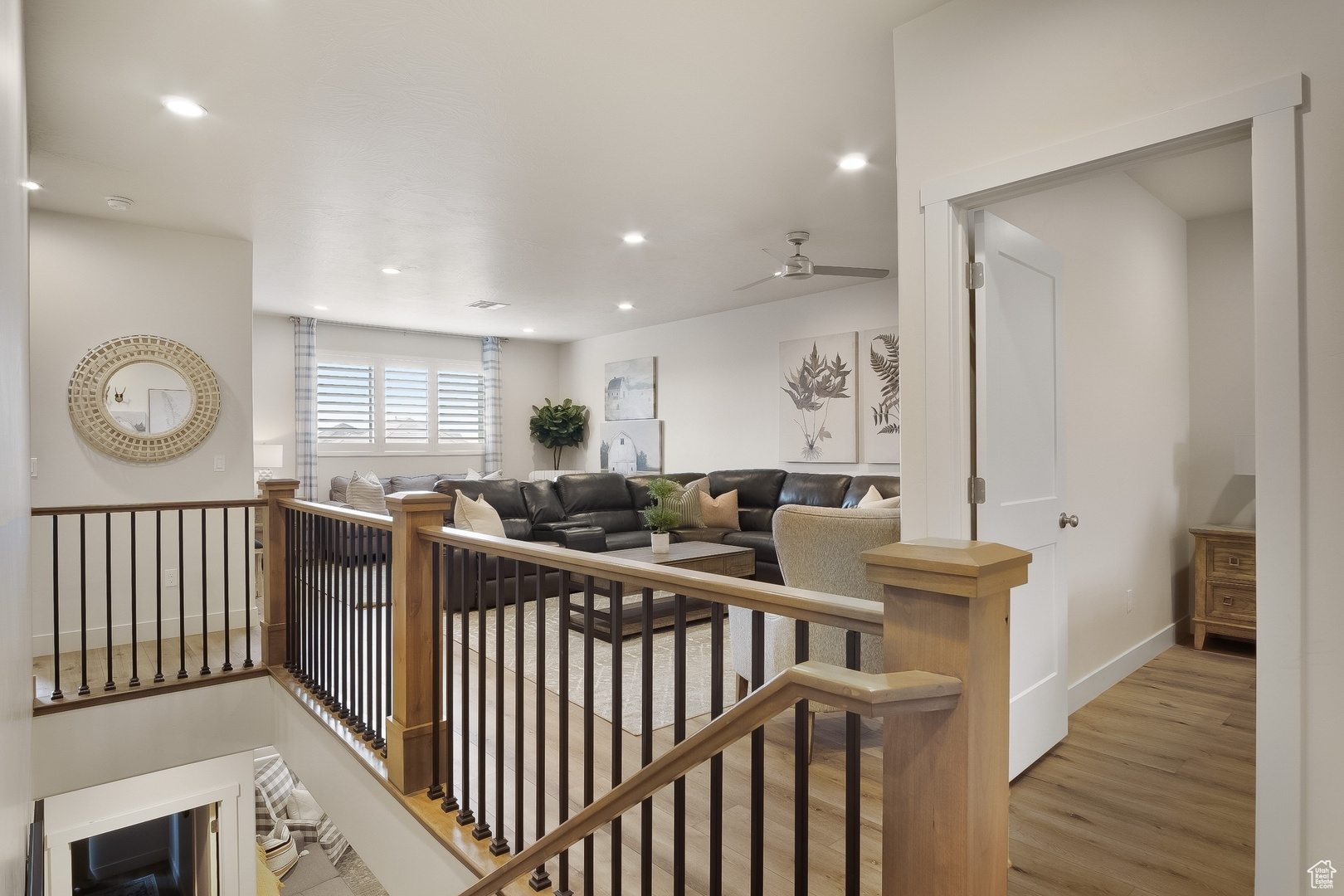 Living room with light hardwood / wood-style flooring and ceiling fan