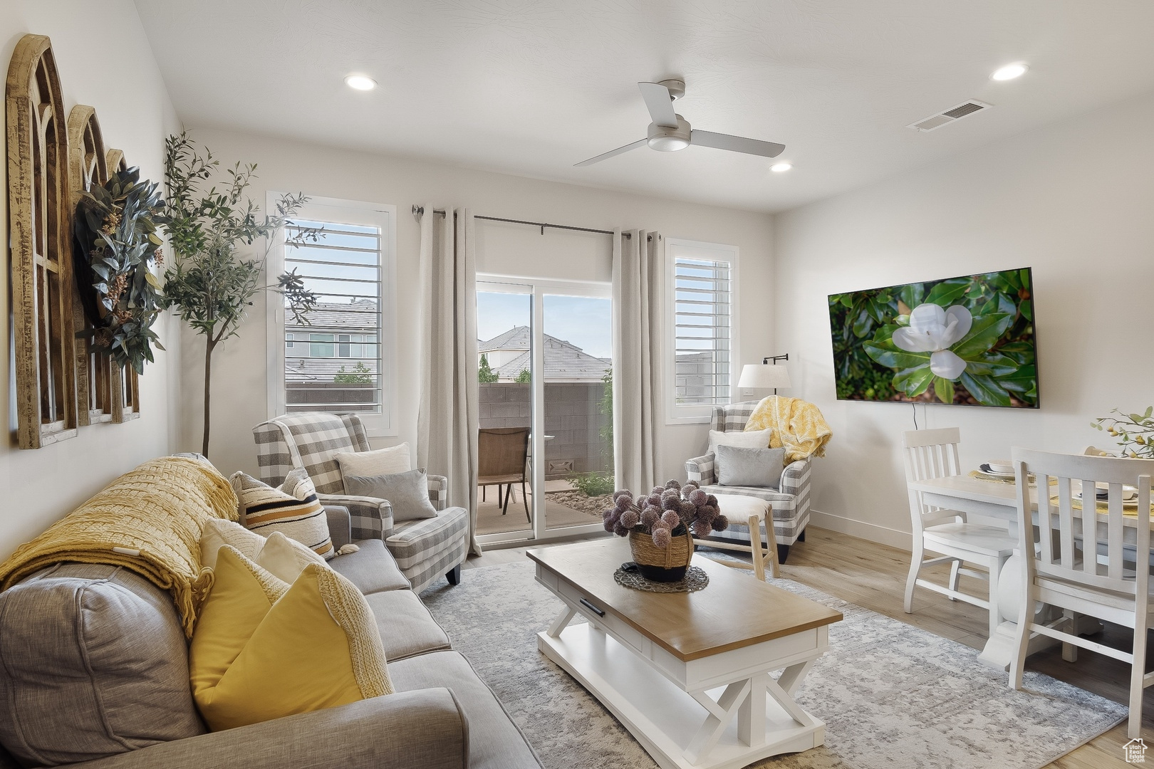 Living room with light hardwood / wood-style flooring and ceiling fan