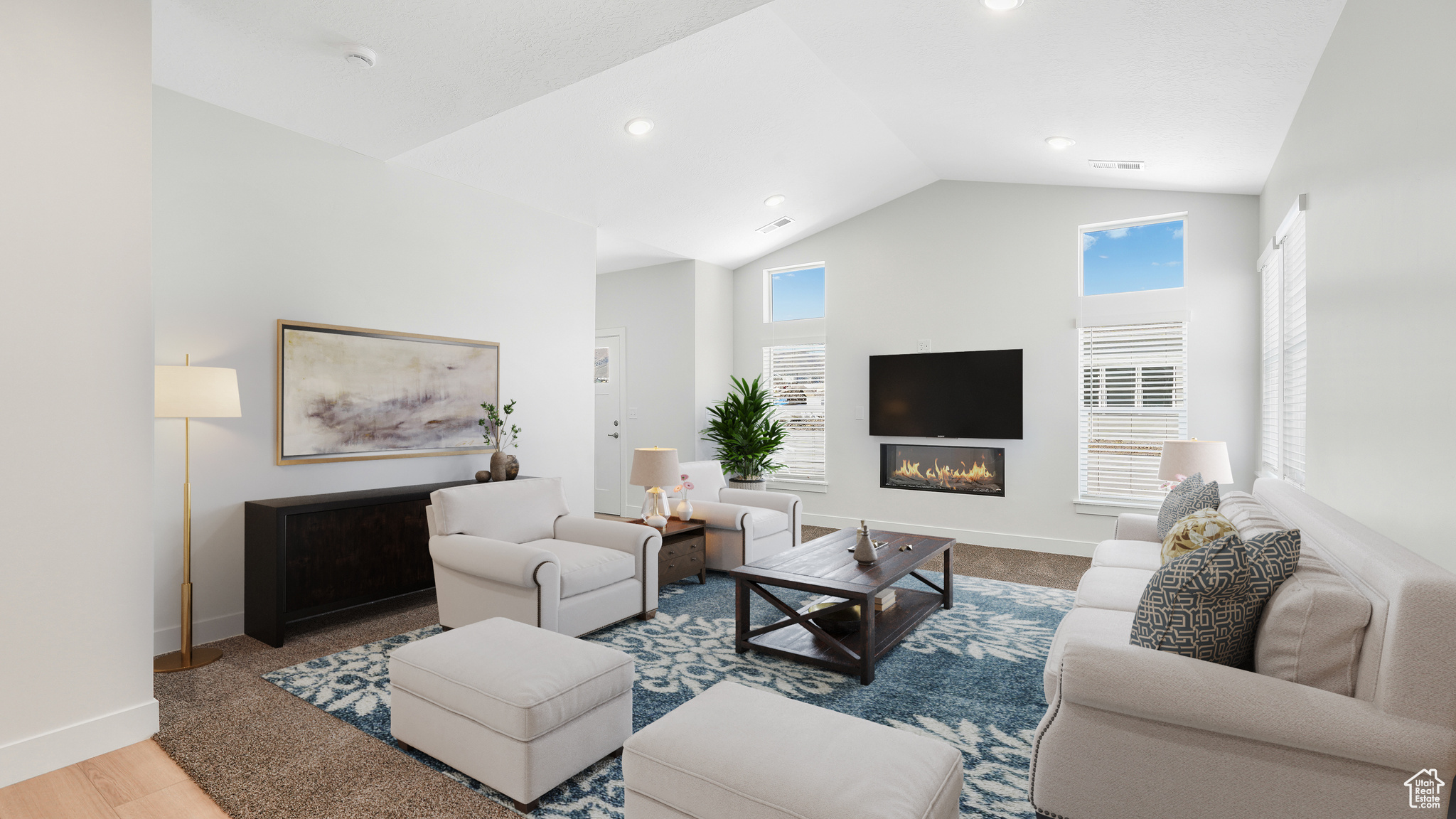 Great room with fireplace and vaulted ceilings, staged.