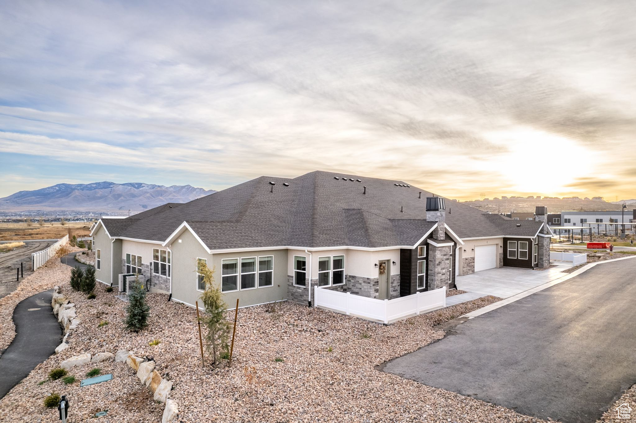 Back house at dusk featuring a mountain view and a garage