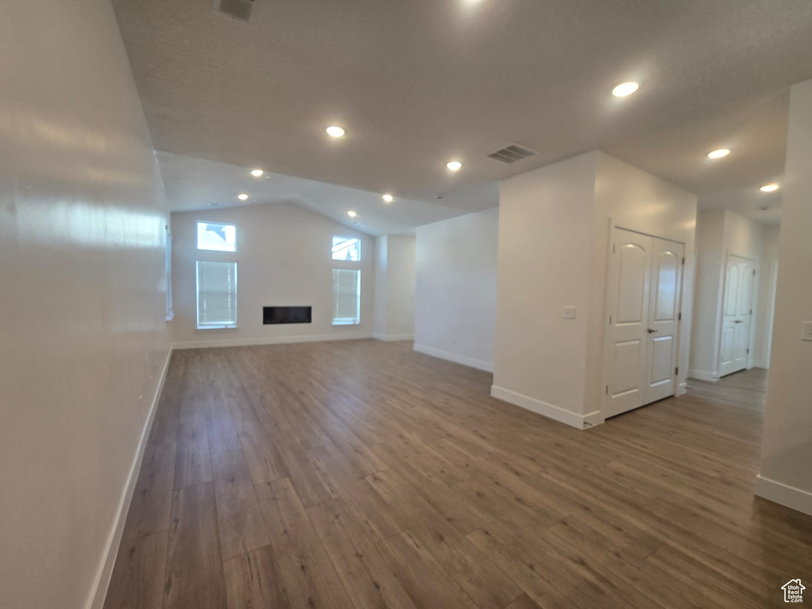 Beautiful open living room featuring vaulted ceilings and continuous LVP flooring throughout.