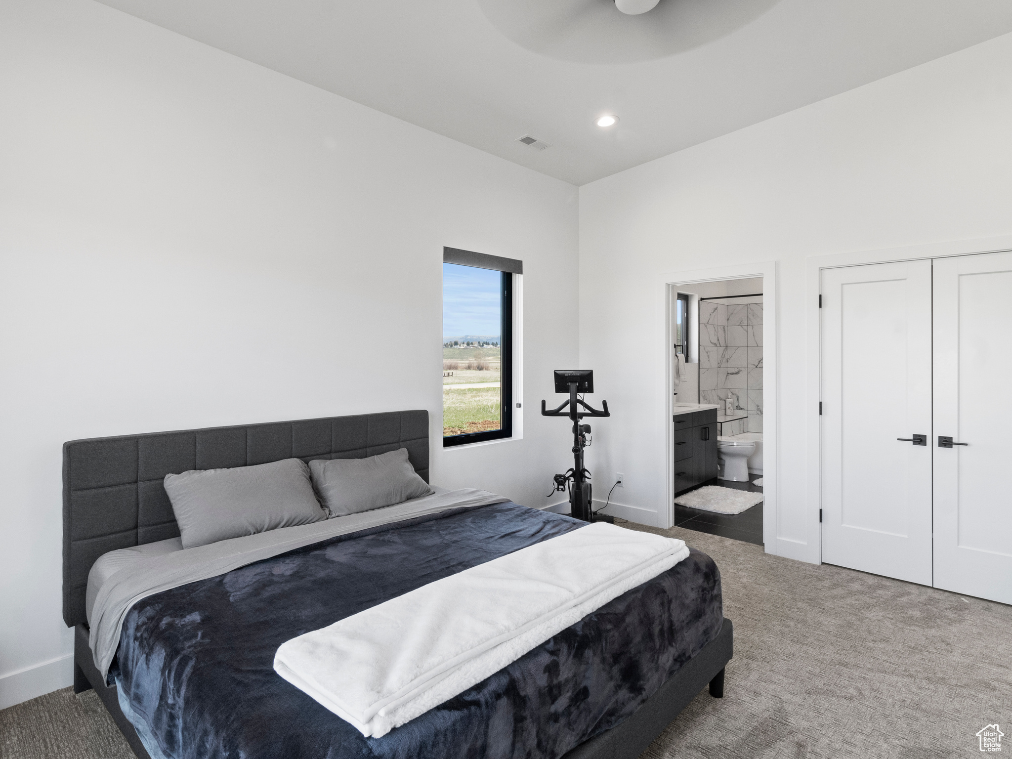 Bedroom with ensuite bath, ceiling fan, and carpet flooring