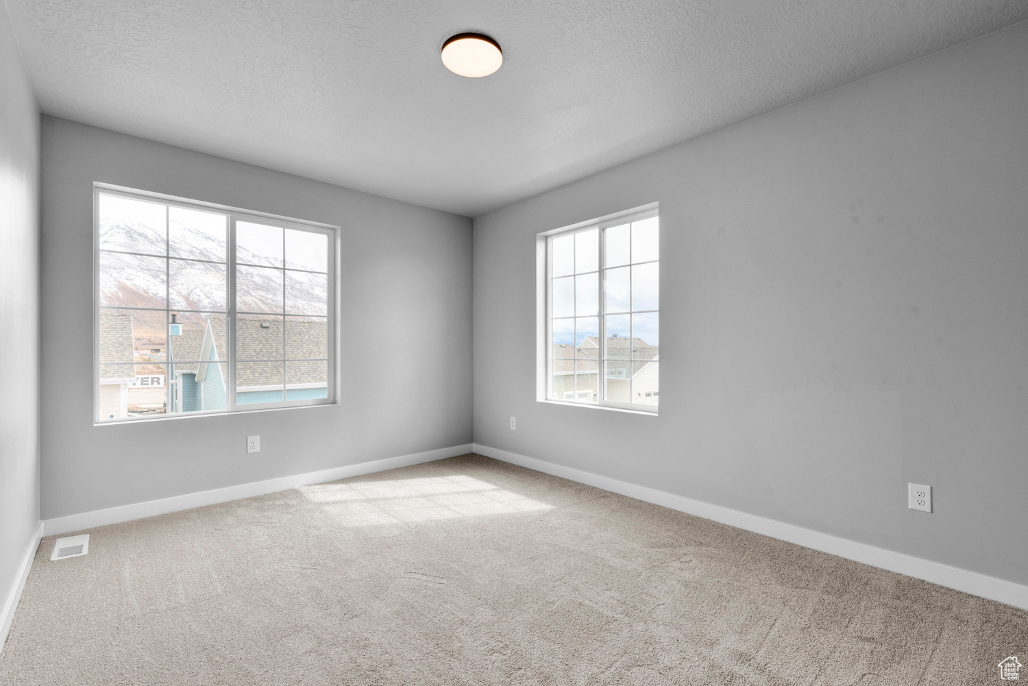 Carpeted empty room with plenty of natural light and a textured ceiling