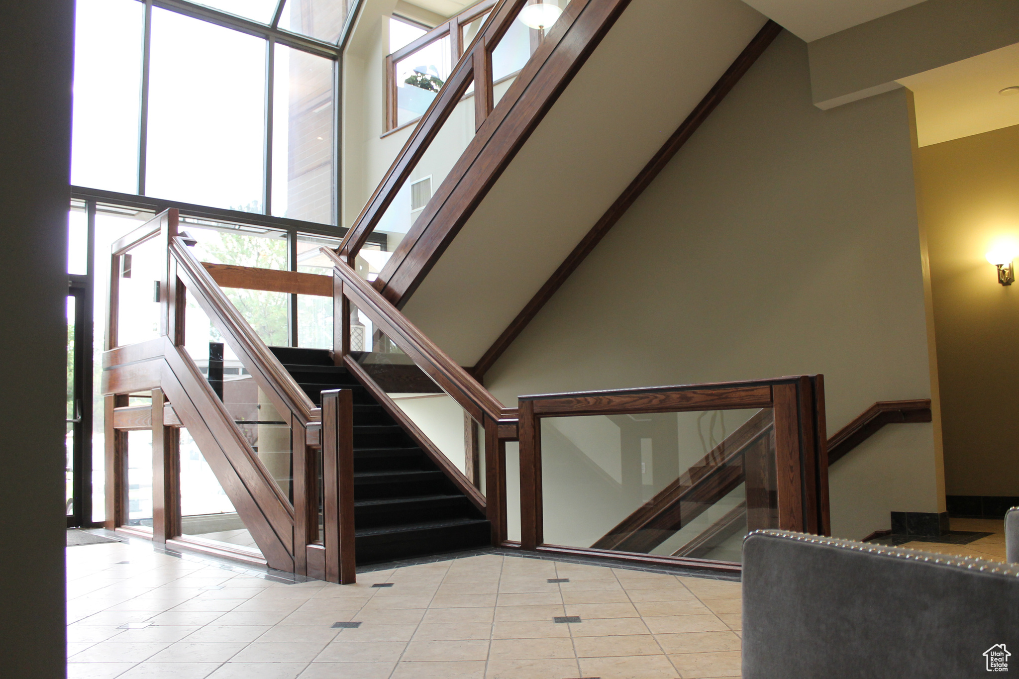 Stairway with a high ceiling and light tile flooring