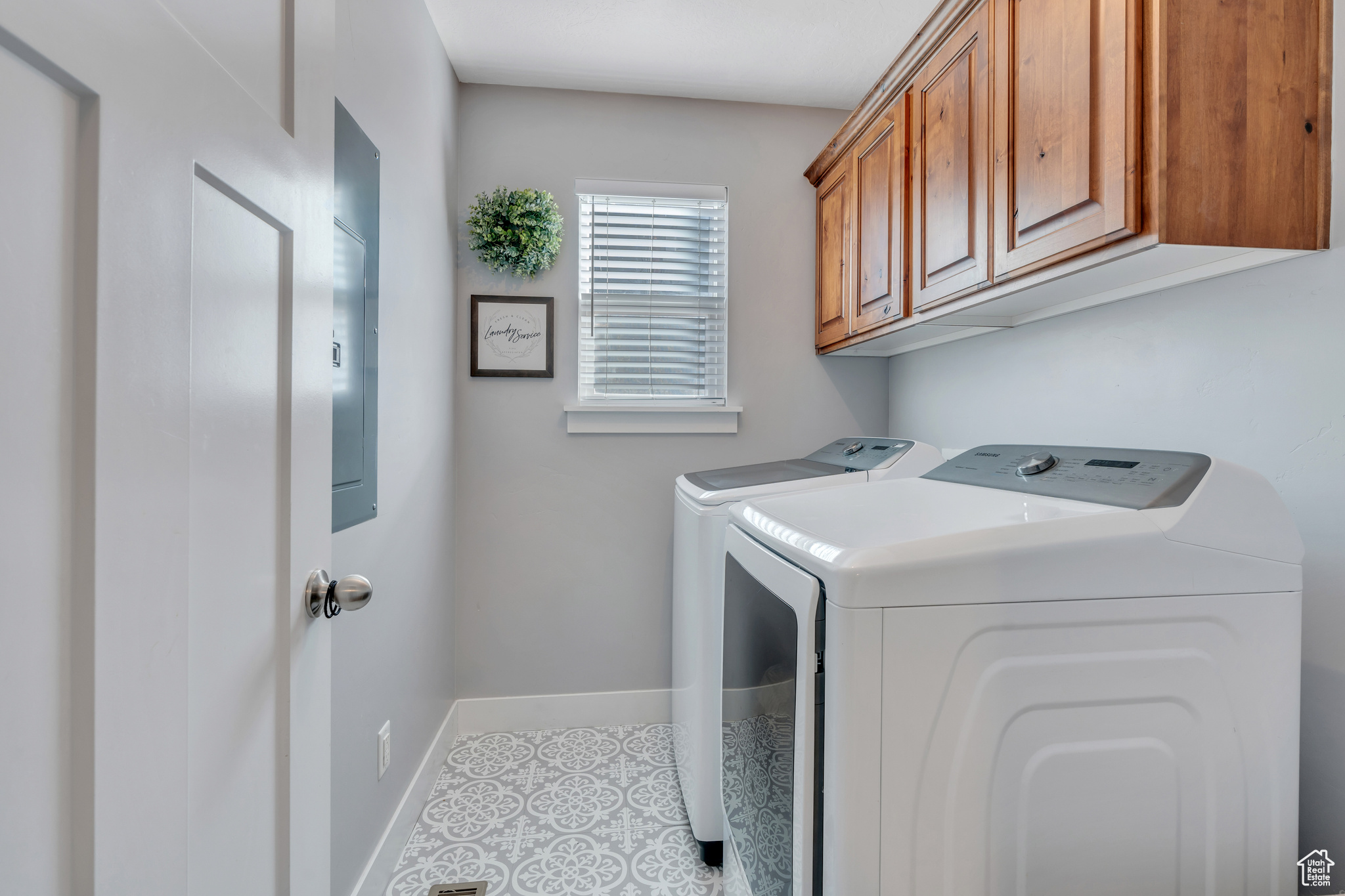 Laundry area featuring washer and clothes dryer, cabinets, and light tile floors