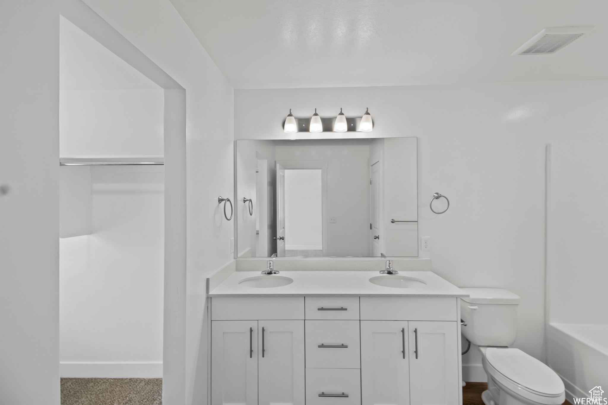 Full bathroom with  shower combination, dual sinks, oversized vanity, and toilet