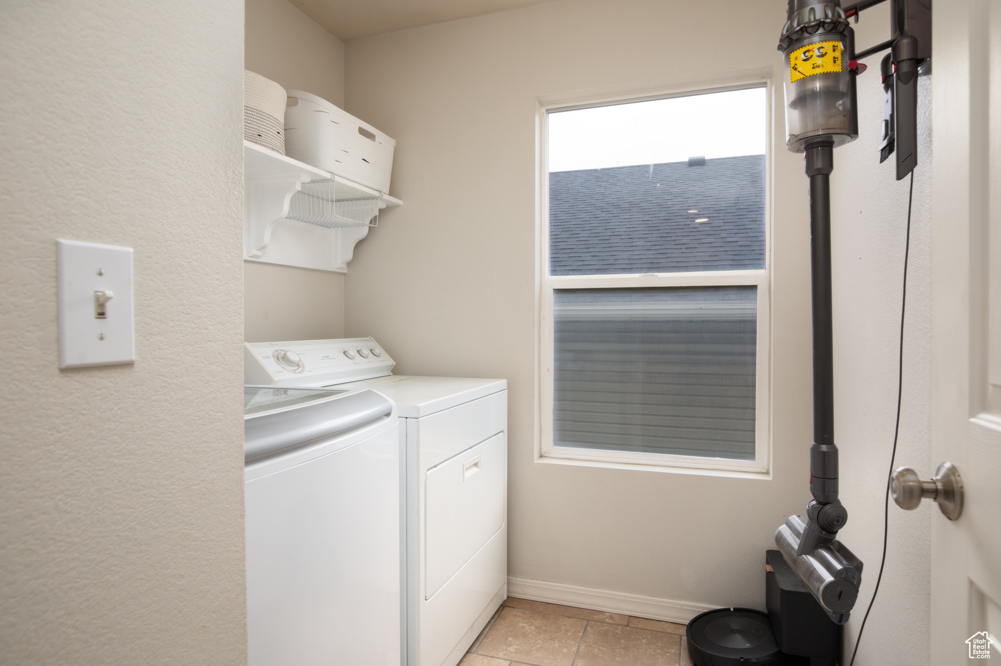 Laundry area with light tile flooring and washer and dryer