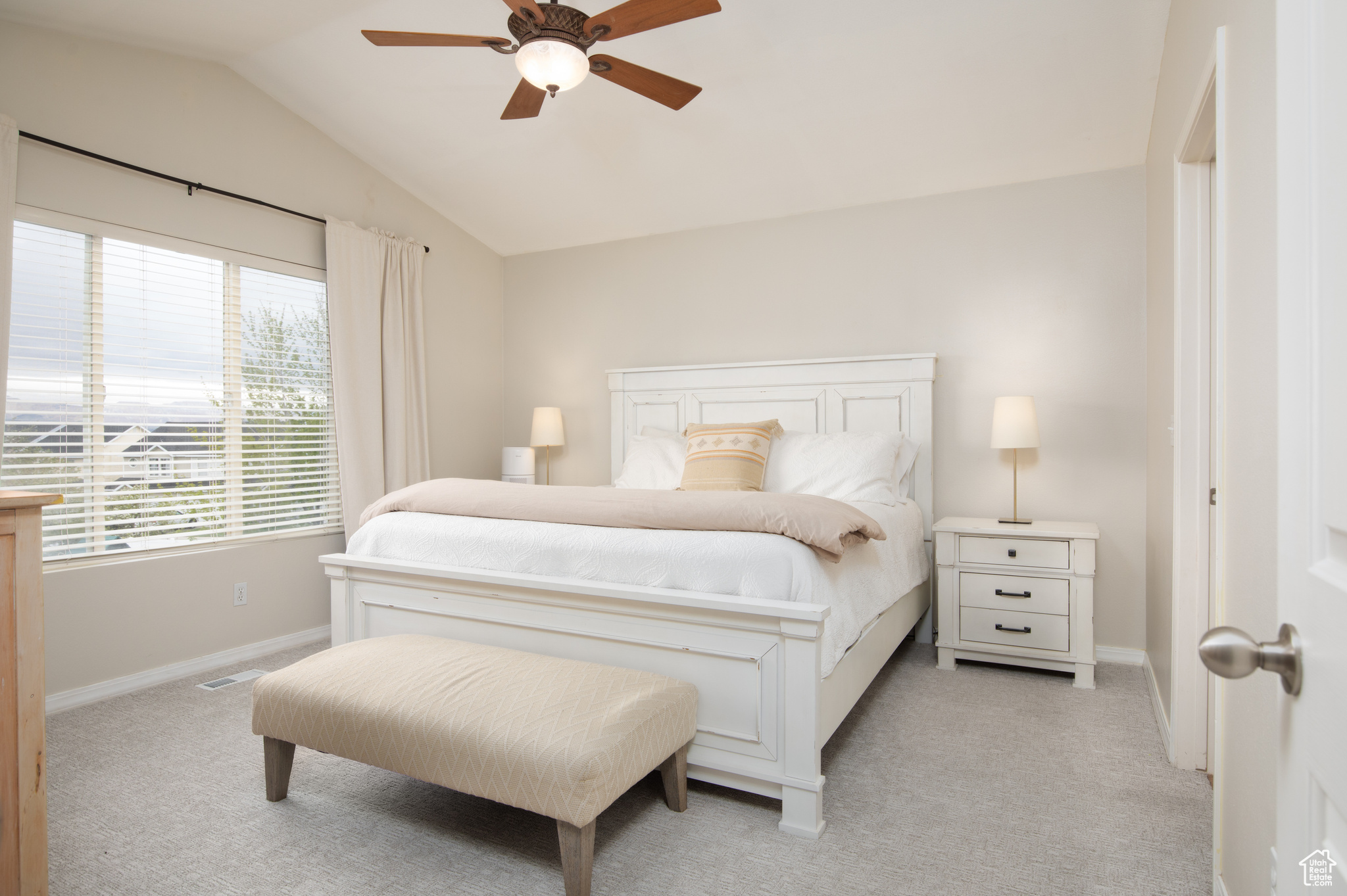 Bedroom featuring light colored carpet, vaulted ceiling, and ceiling fan