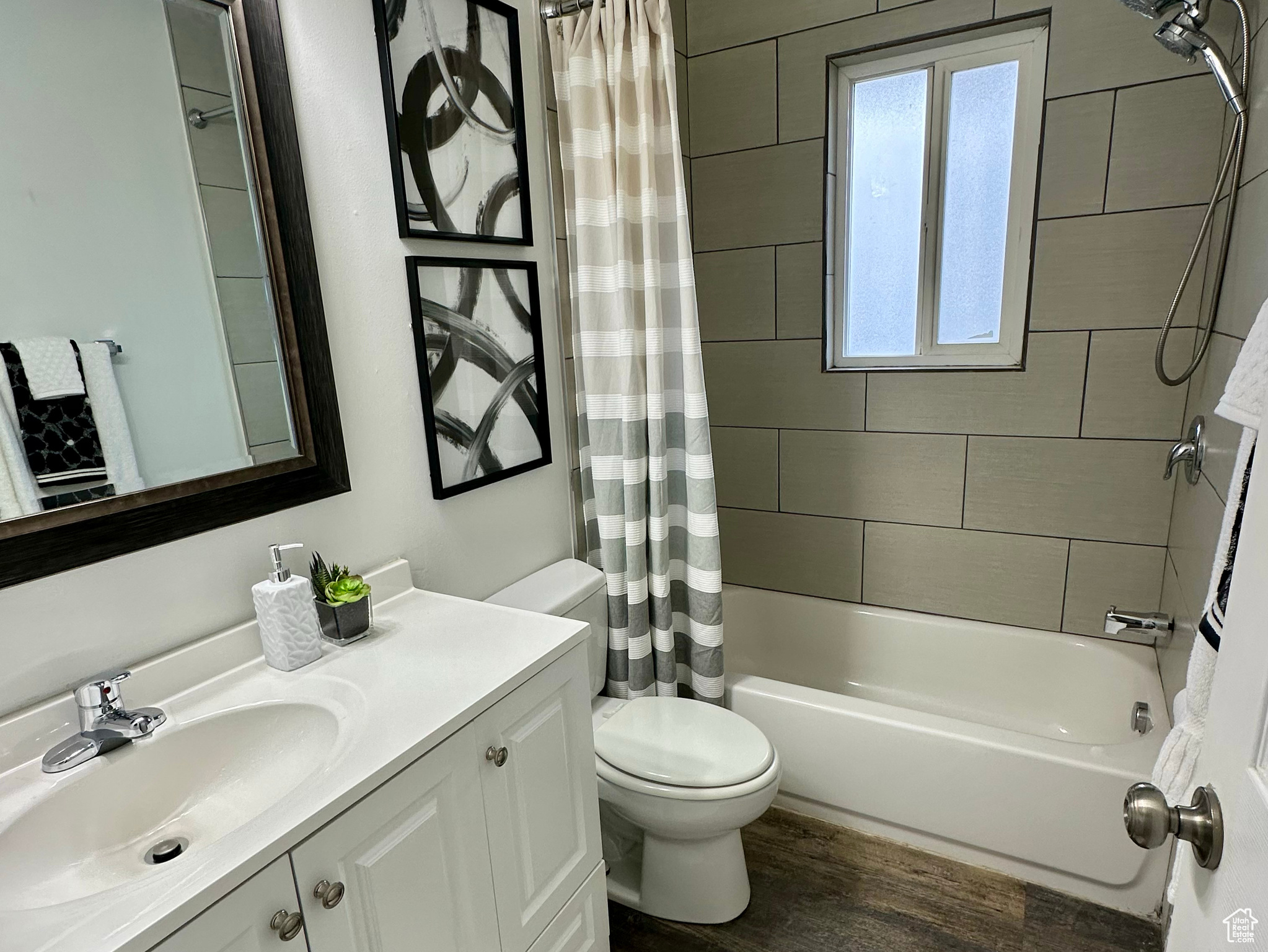 Full bathroom featuring shower / tub combo, toilet, vanity, and hardwood / wood-style floors