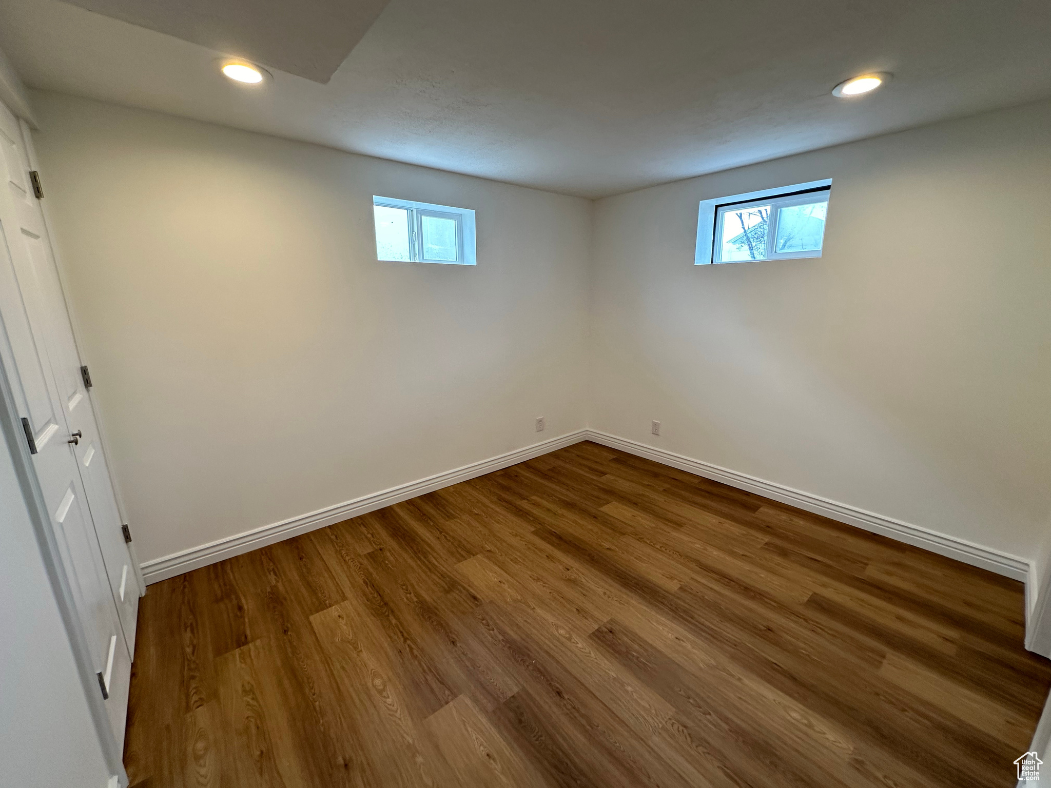 Unfurnished room featuring a wealth of natural light and dark hardwood / wood-style flooring