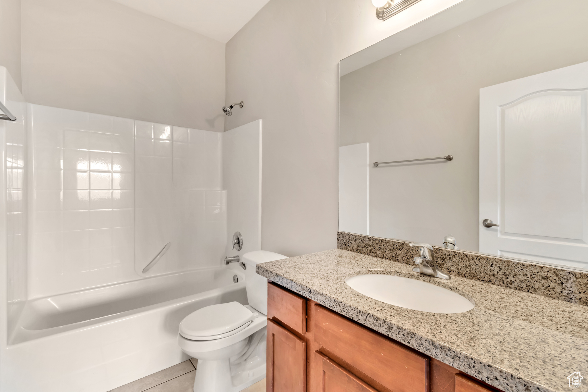 Full bathroom featuring shower / washtub combination, tile flooring, vanity with extensive cabinet space, and toilet