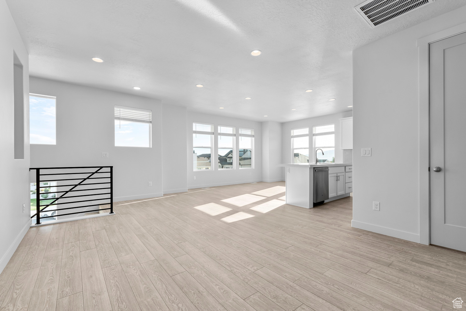 Unfurnished living room featuring light hardwood / wood-style floors and a wealth of natural light