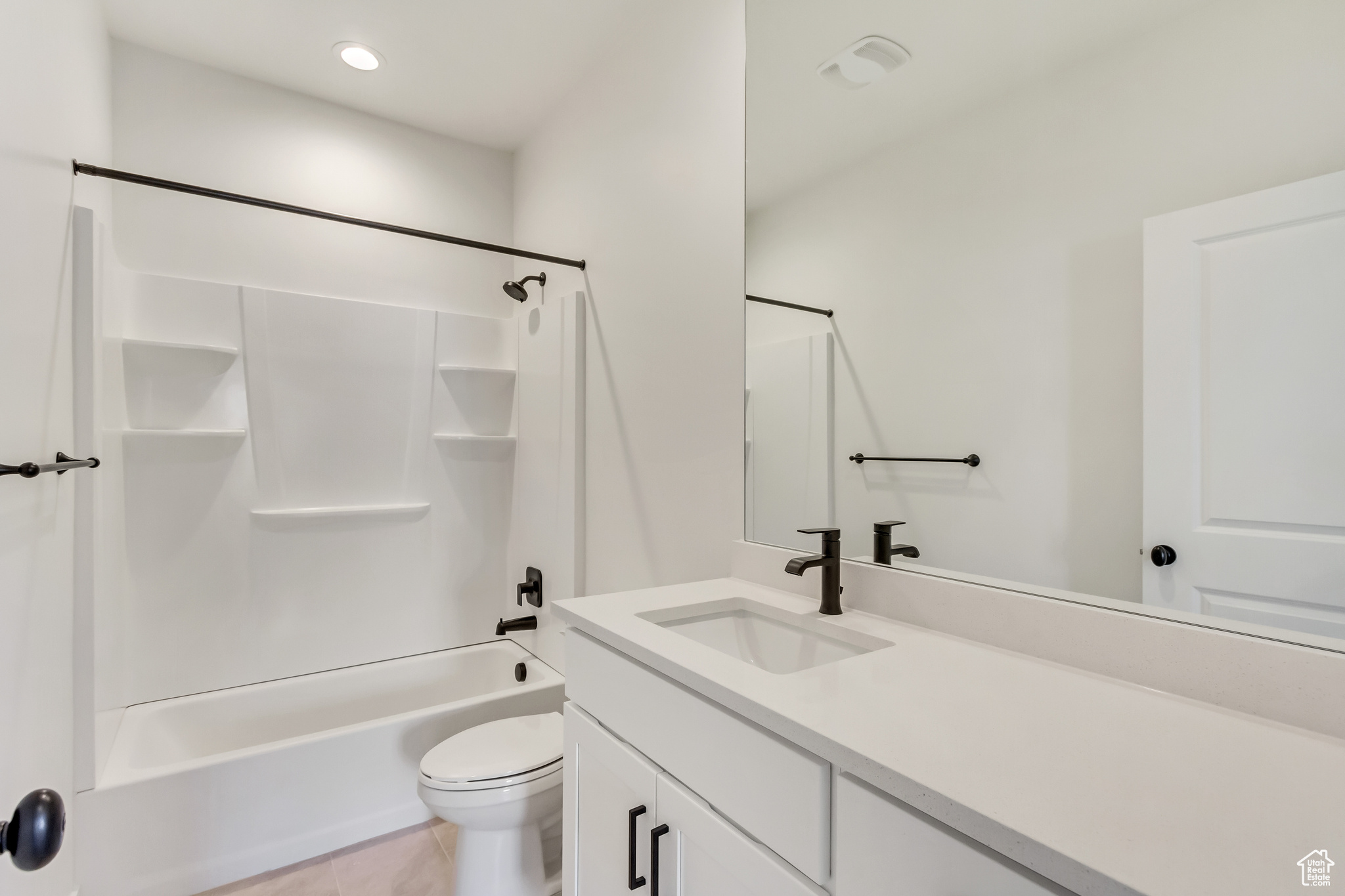 Full bathroom featuring washtub / shower combination, vanity, toilet, and tile floors