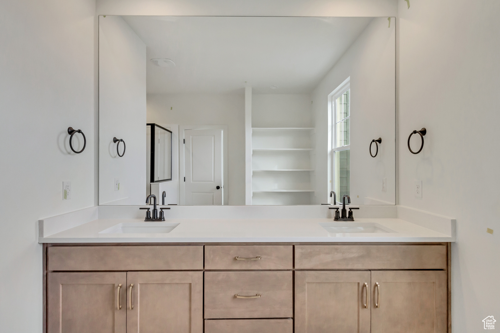 Bathroom featuring dual sinks, oversized vanity, and built in shelves
