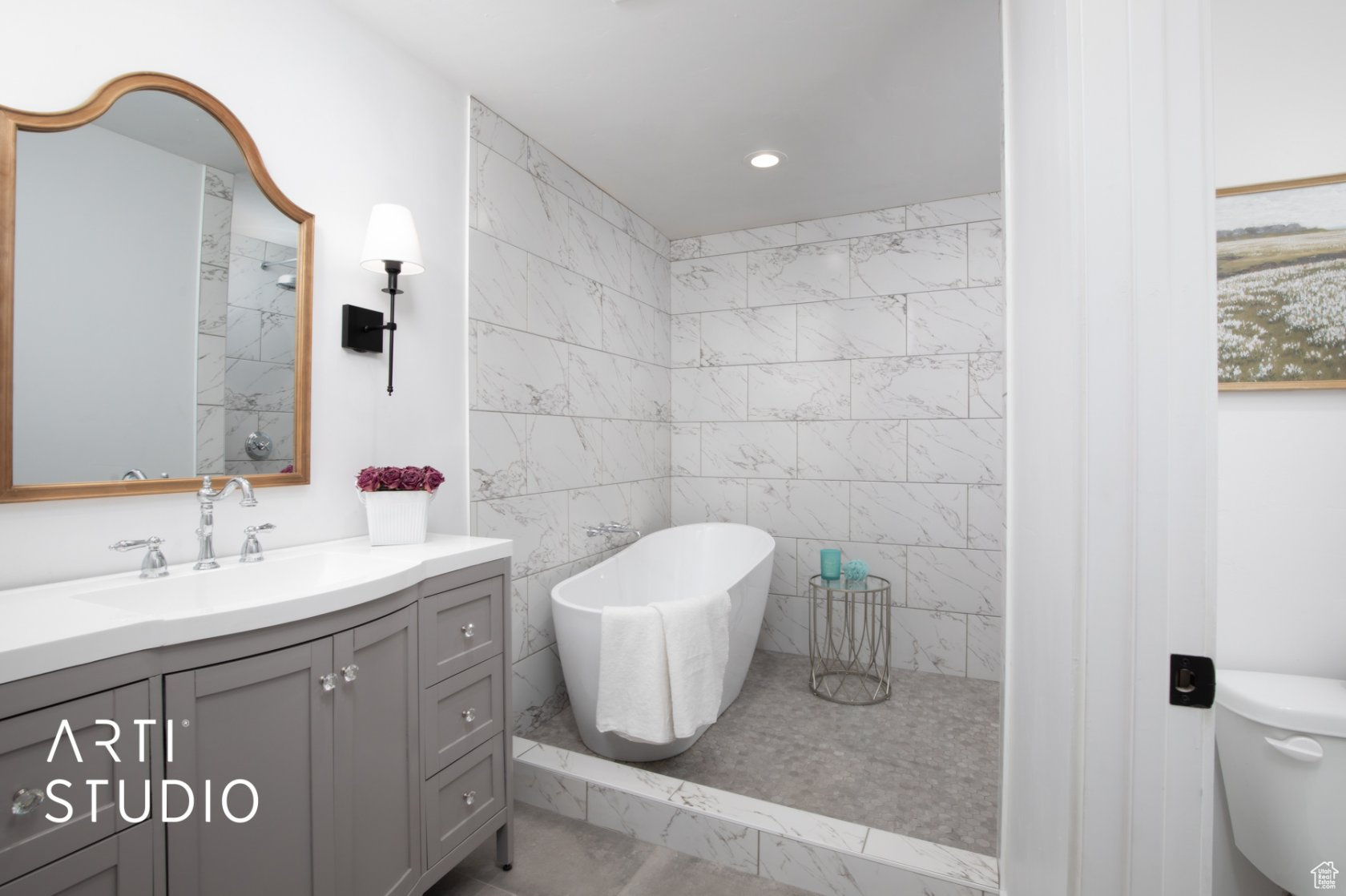 Bathroom featuring over sized tiled wetroom with tile walls and floor, toilet, and vanity