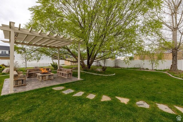 View of yard with a fire pit, a patio, and a pergola