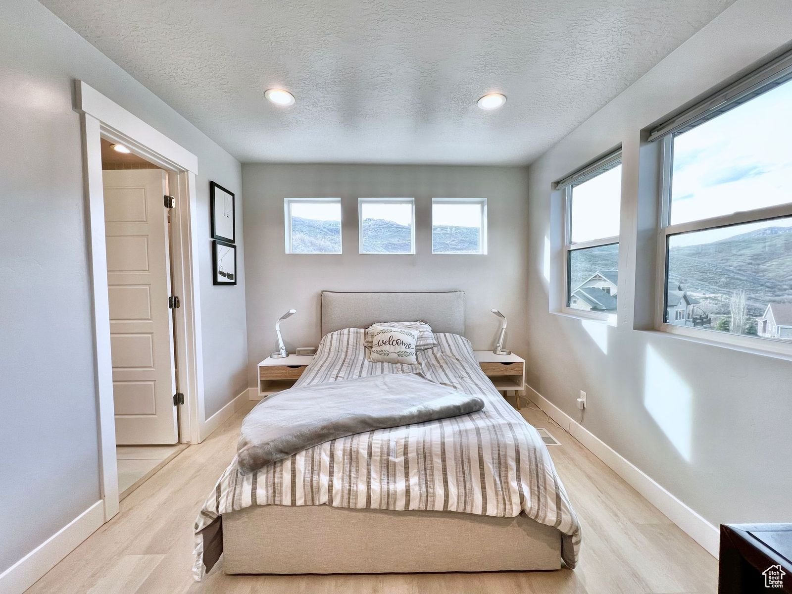 Bedroom with a textured ceiling and light hardwood / wood-style floors