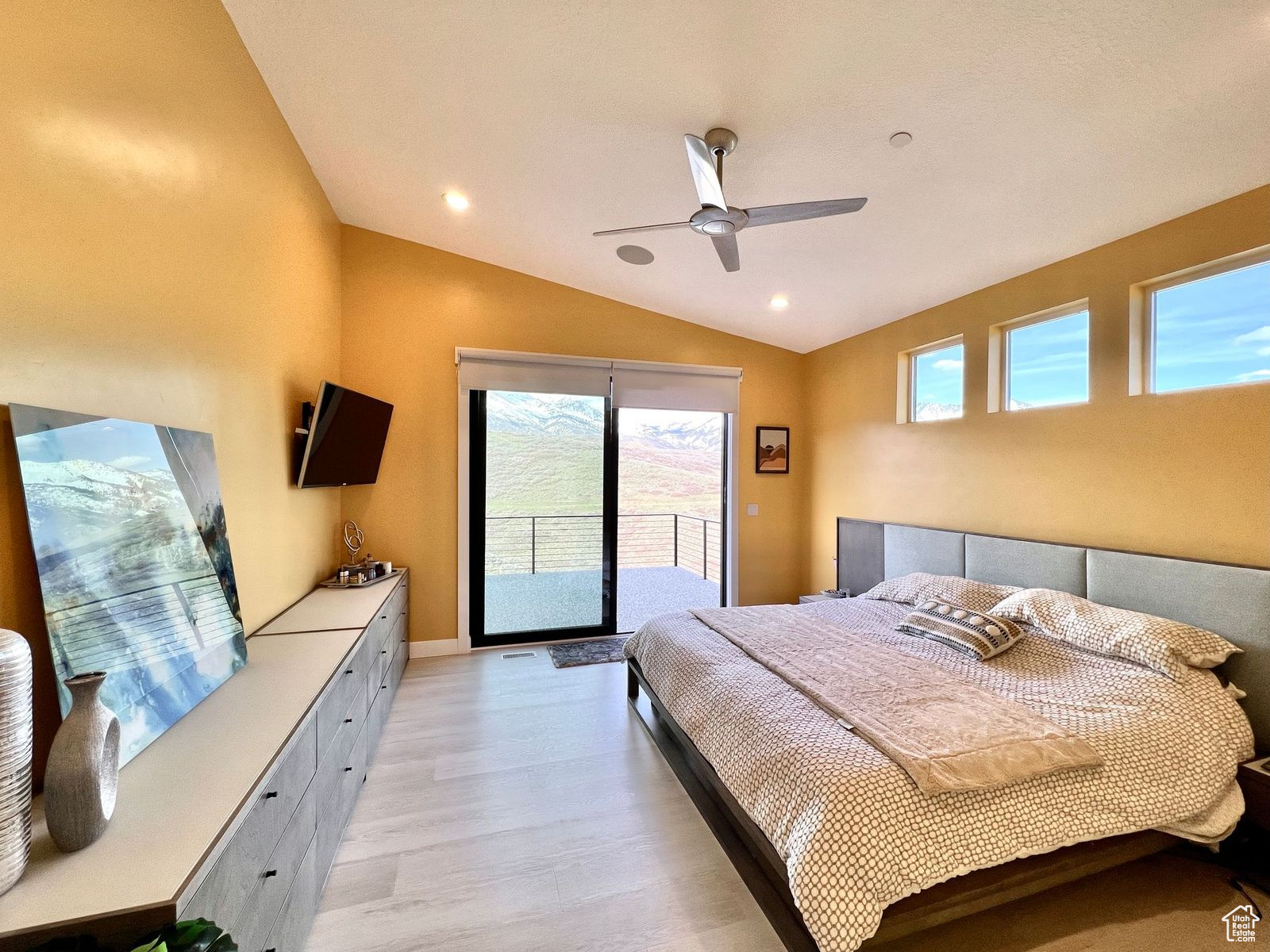 Bedroom featuring ceiling fan, vaulted ceiling, light hardwood / wood-style floors, and access to outside