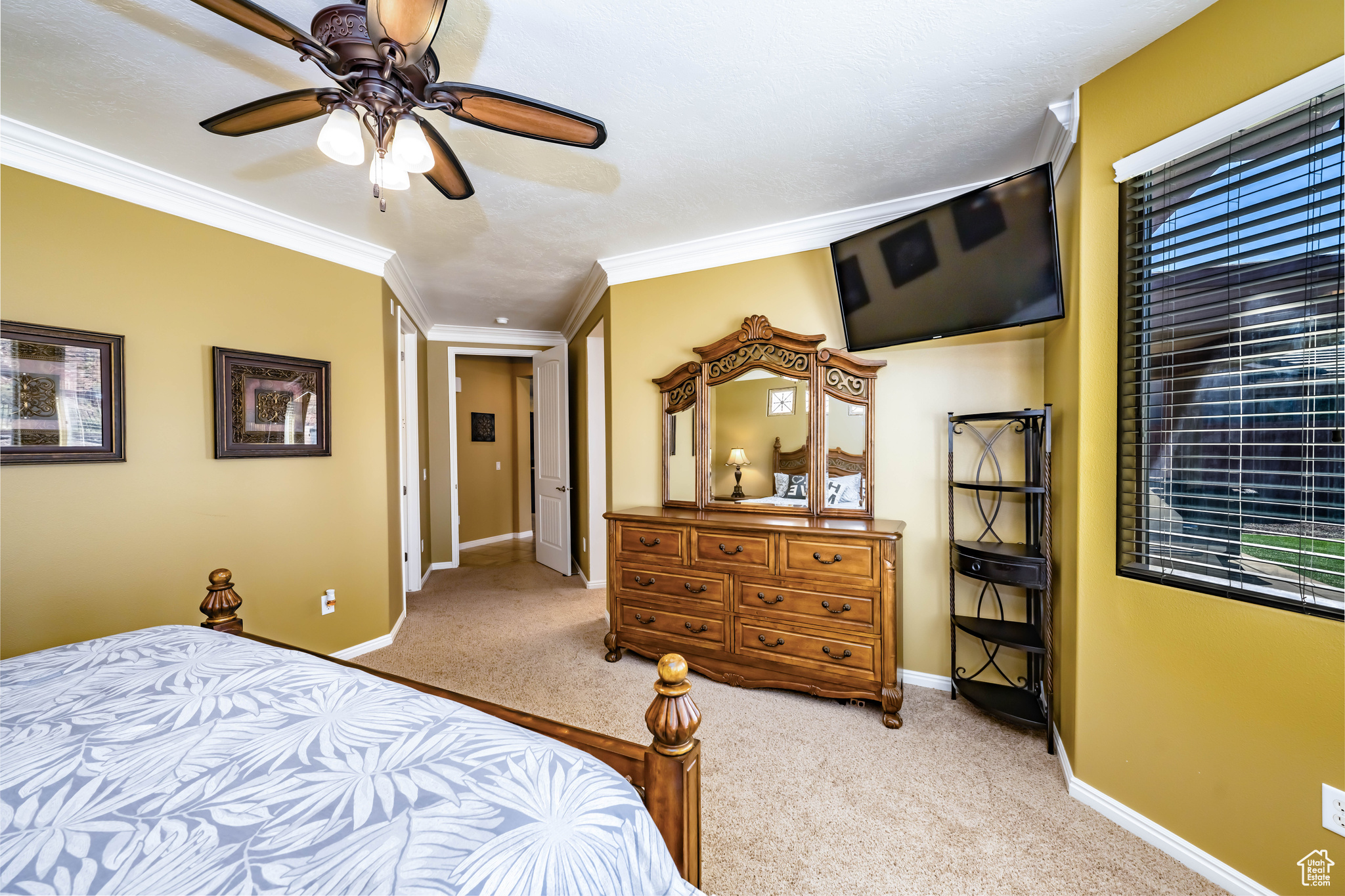 Primary Bedroom featuring ornamental molding, light colored carpet, and ceiling fan
