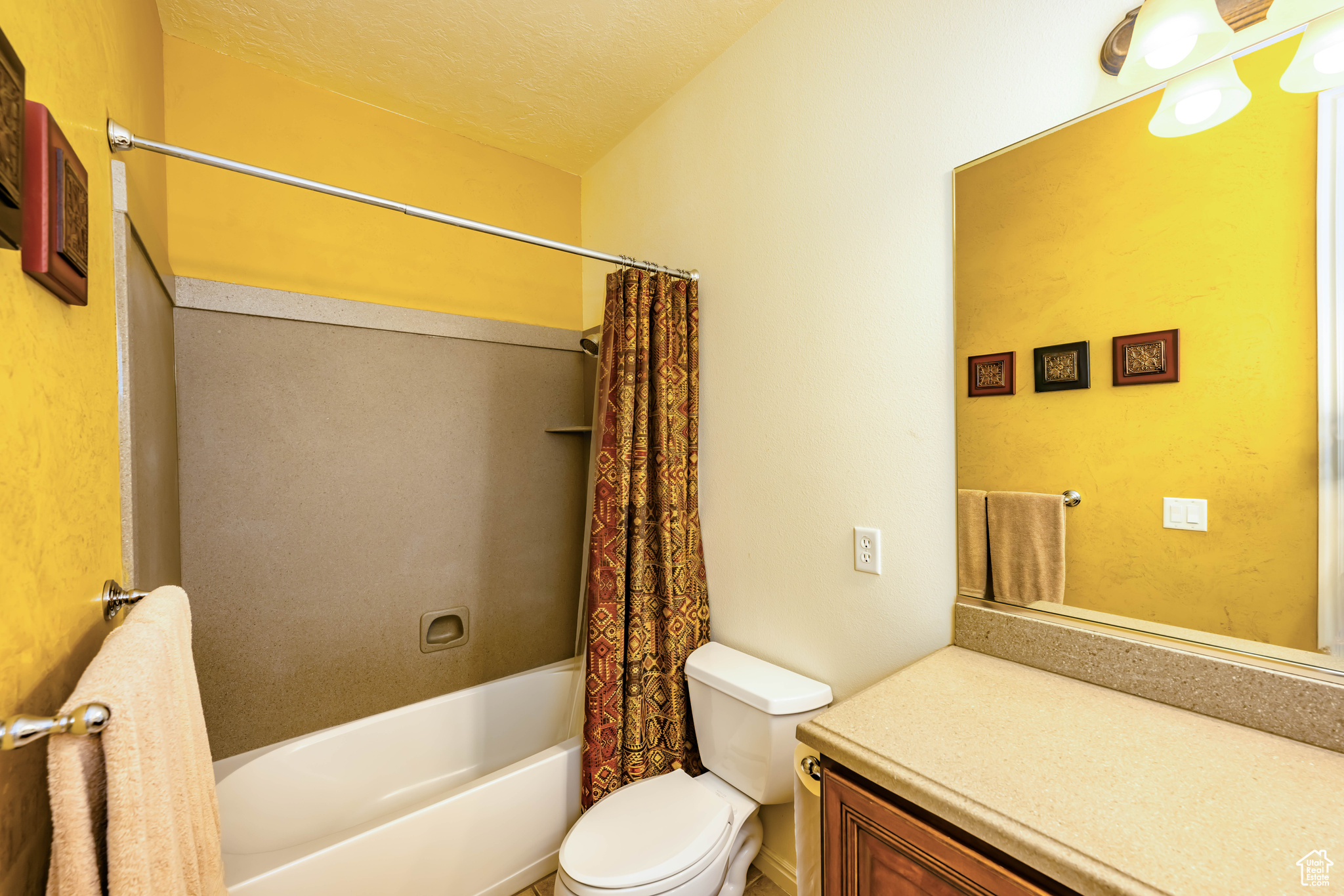 Full second bathroom featuring shower / bathtub combination with curtain, toilet, vanity, and a textured ceiling