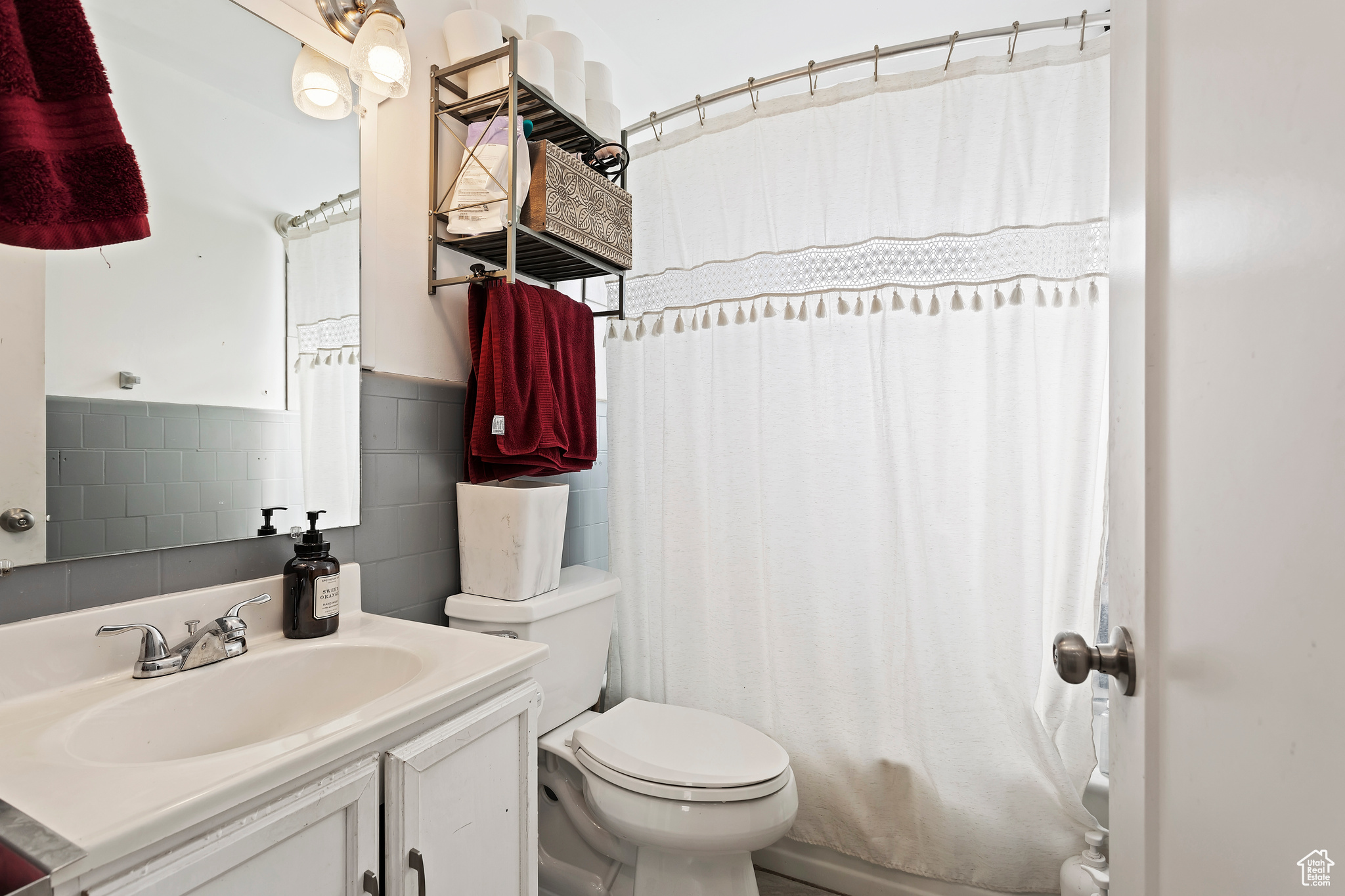 Bathroom with oversized vanity, tile walls, and toilet