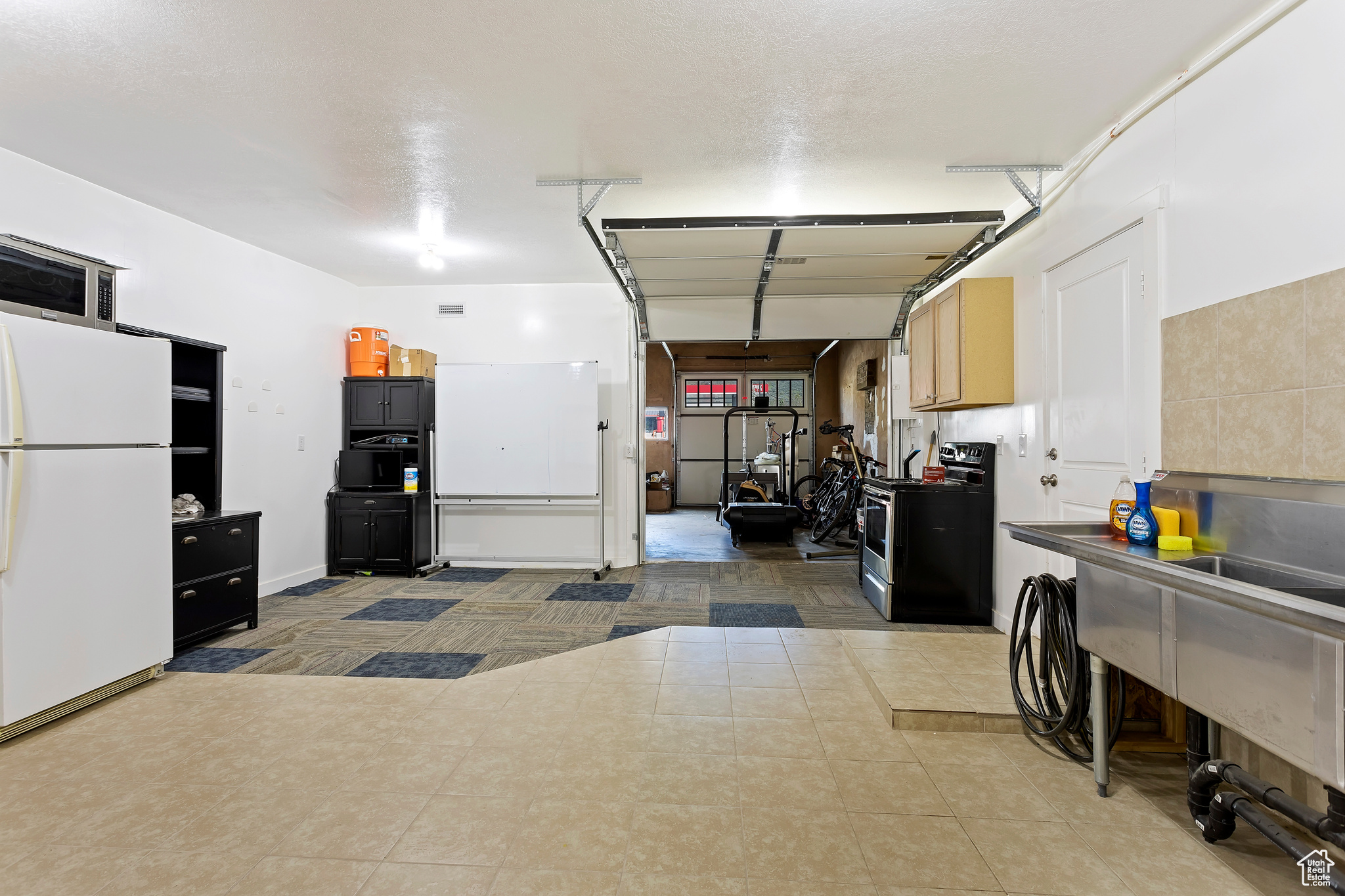 Garage featuring white refrigerator