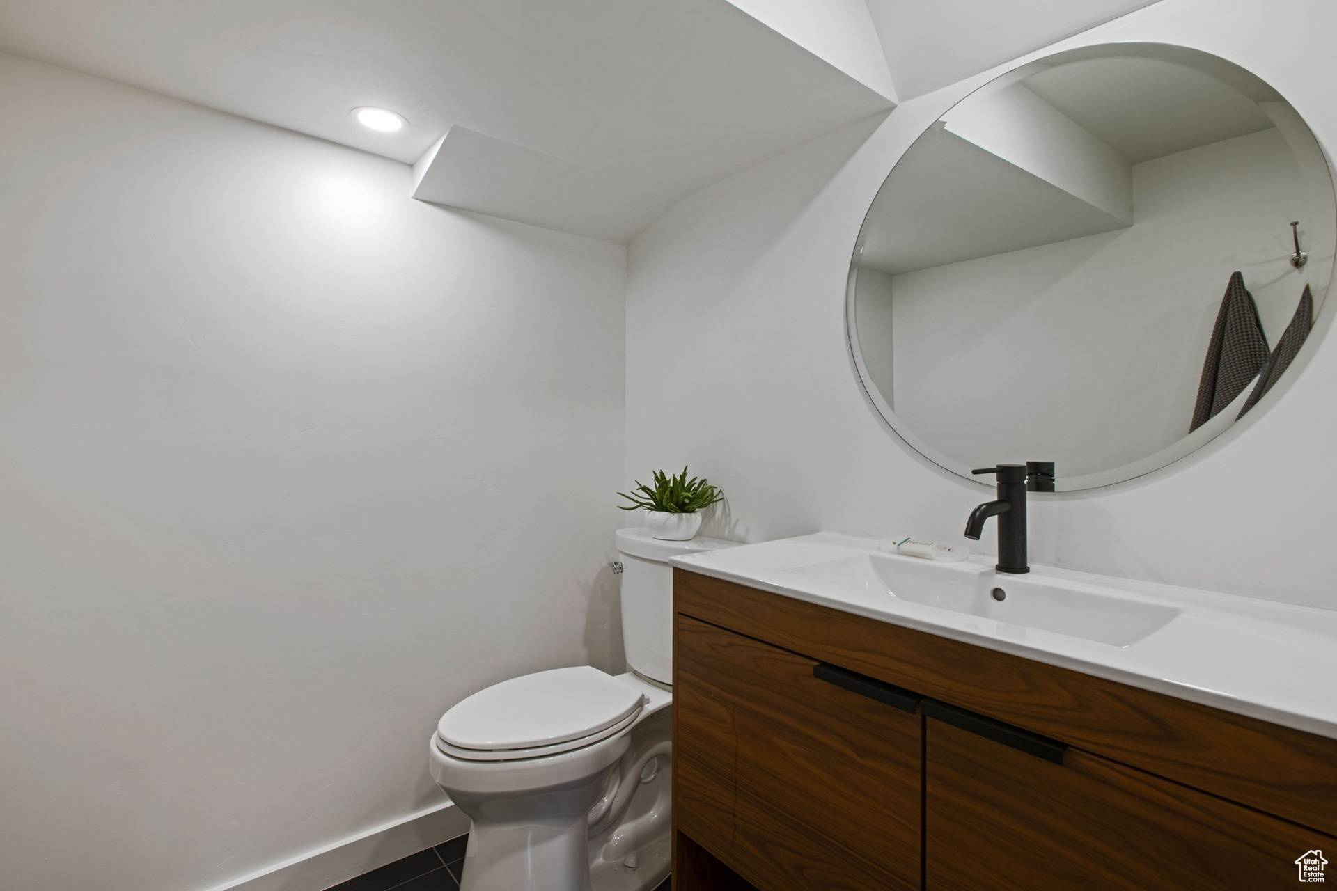Bathroom featuring toilet, vanity, and tile flooring
