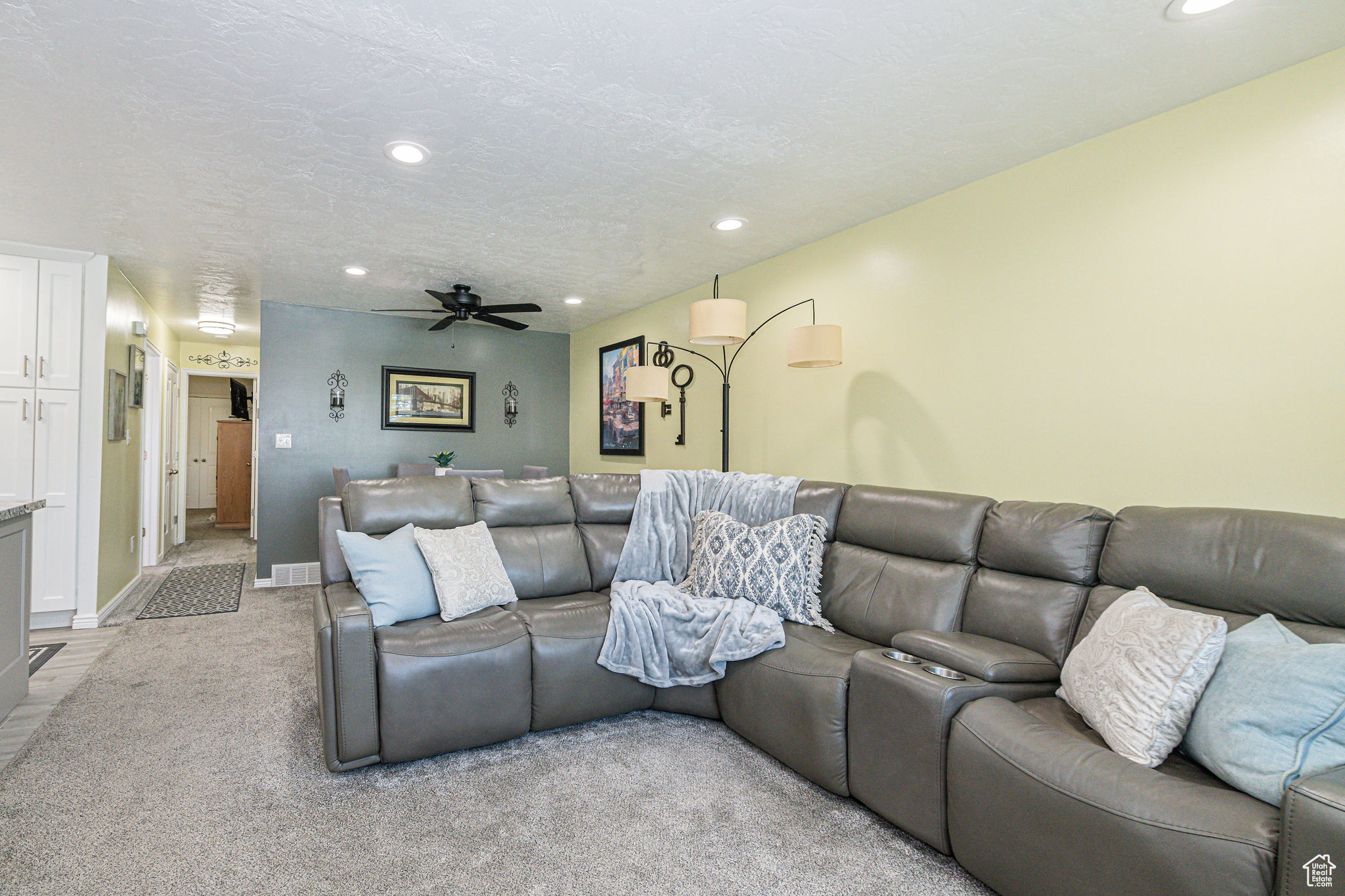 Interior space featuring light carpet, ceiling fan, and a textured ceiling