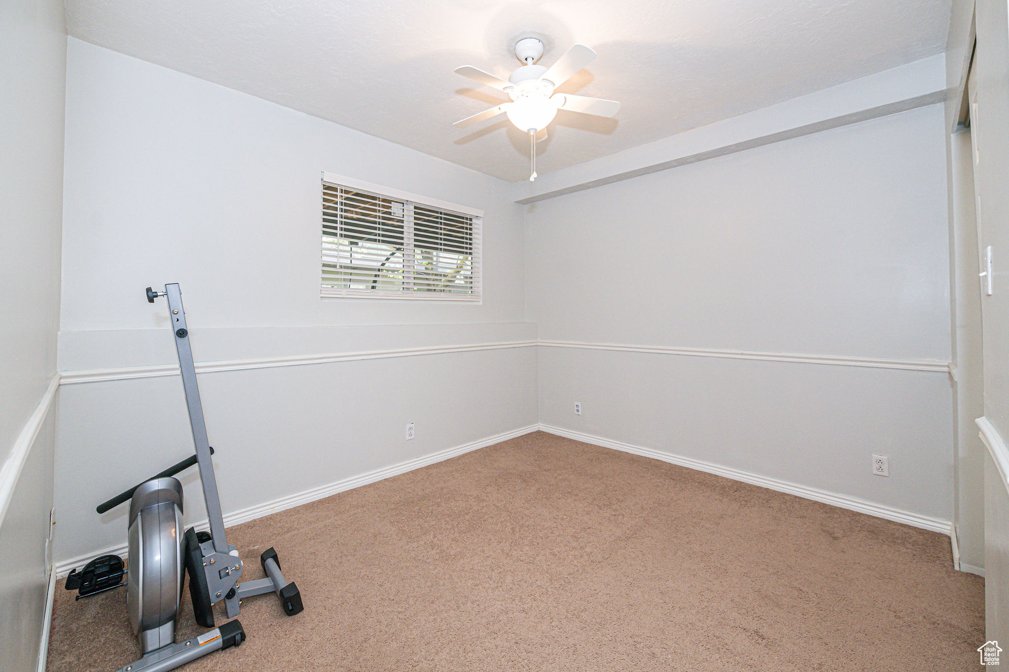 Workout room featuring light carpet and ceiling fan