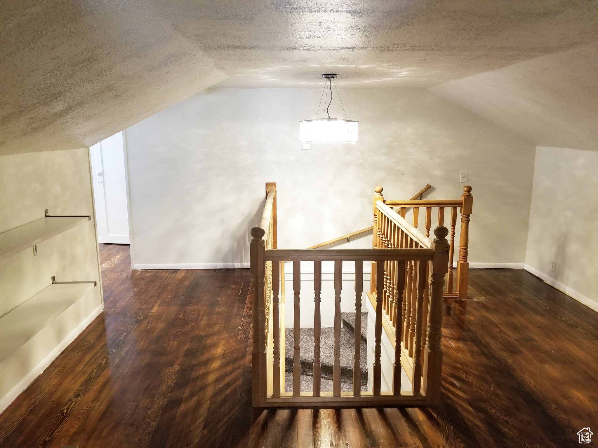Bonus room with a textured ceiling, dark hardwood / wood-style flooring, and vaulted ceiling