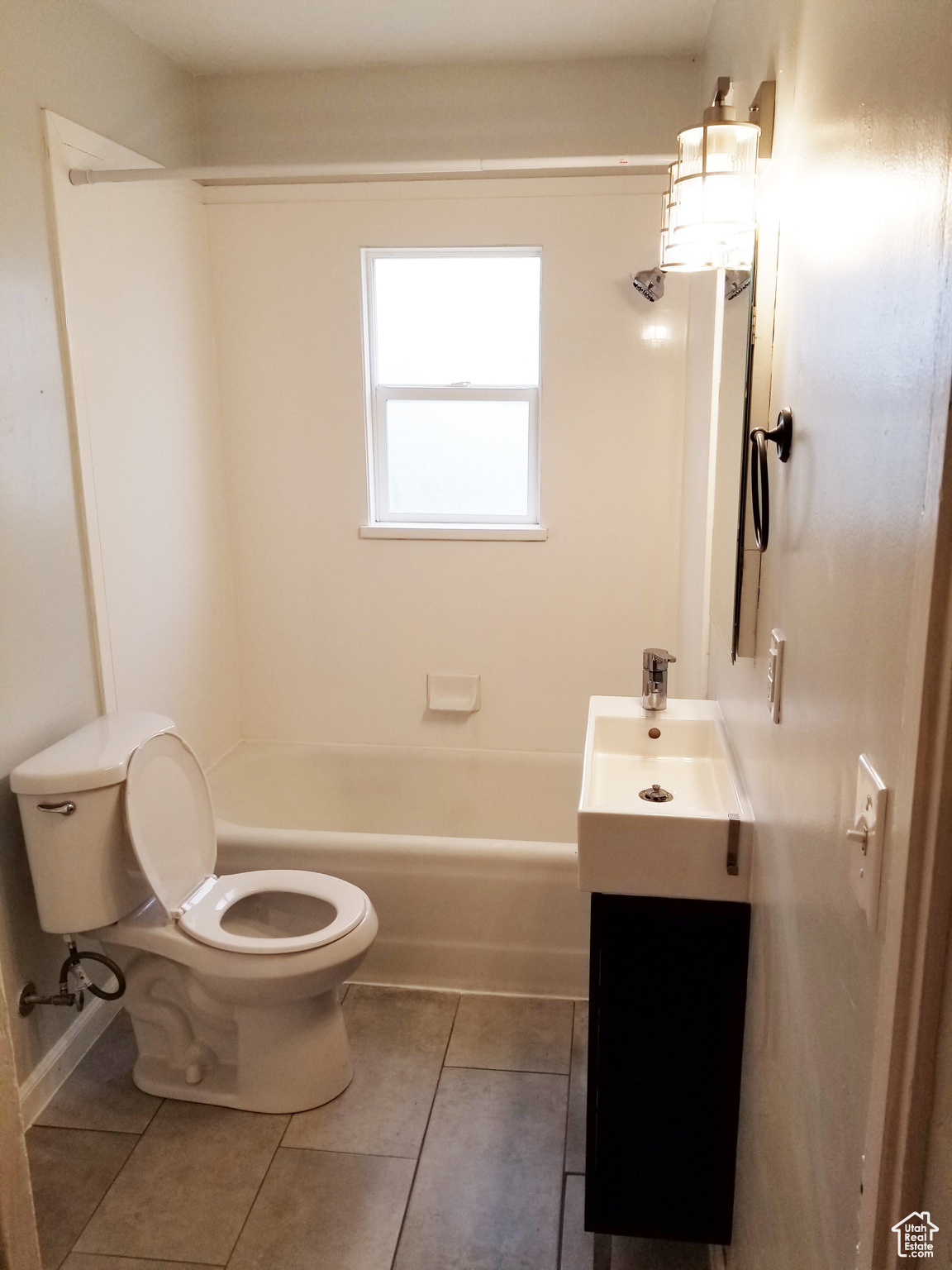 Full bathroom with tile flooring,  shower combination, vanity, and toilet