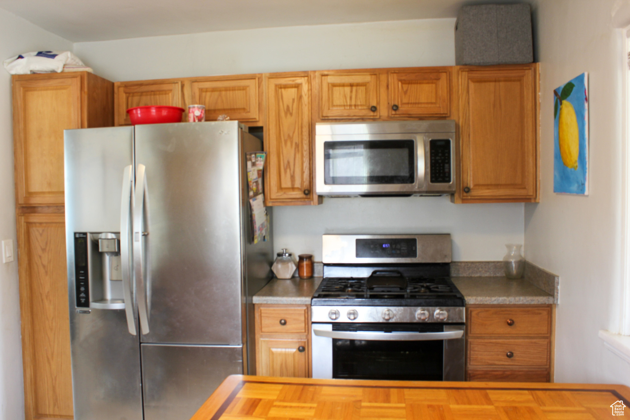 Kitchen featuring appliances with stainless steel finishes, wooden counters, and parquet flooring