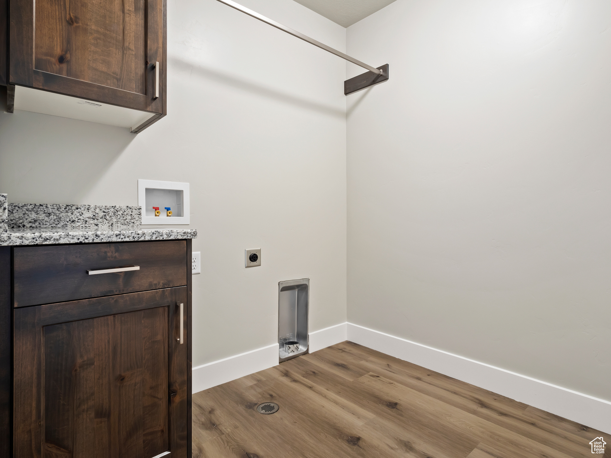 Laundry room featuring hookup for an electric dryer, dark hardwood / wood-style flooring, cabinets, and washer hookup
