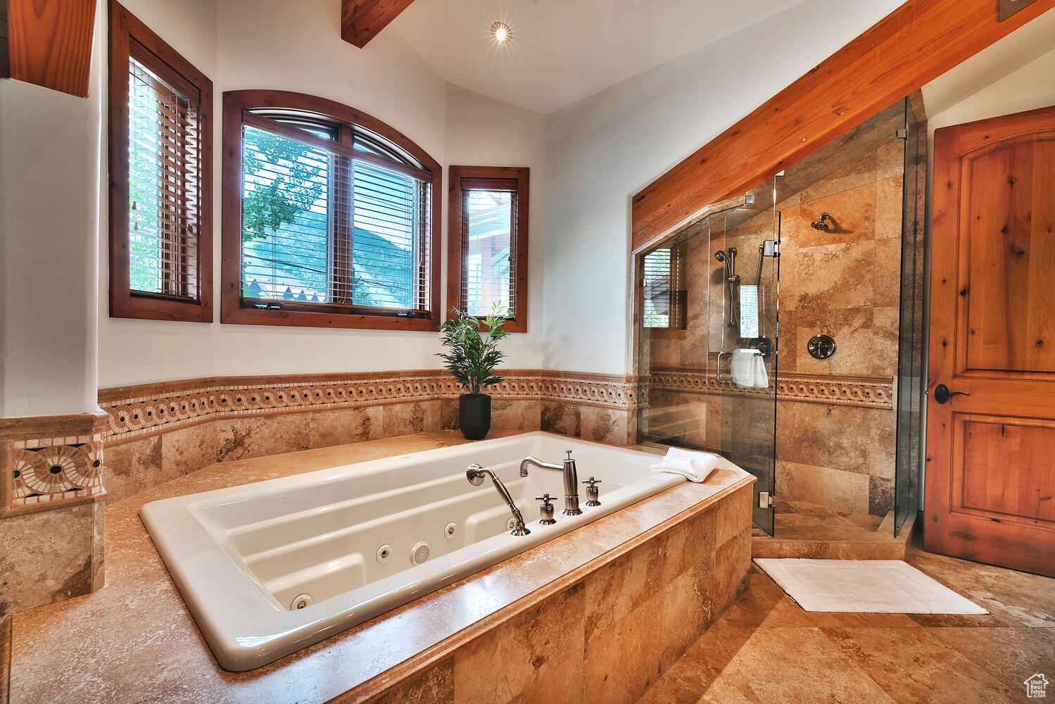 Bathroom with lofted ceiling with beams, tile floors, and separate shower and tub