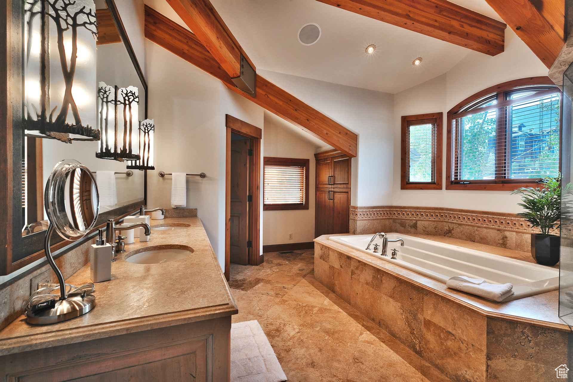 Bathroom with tiled bath, vanity, lofted ceiling with beams, and tile flooring