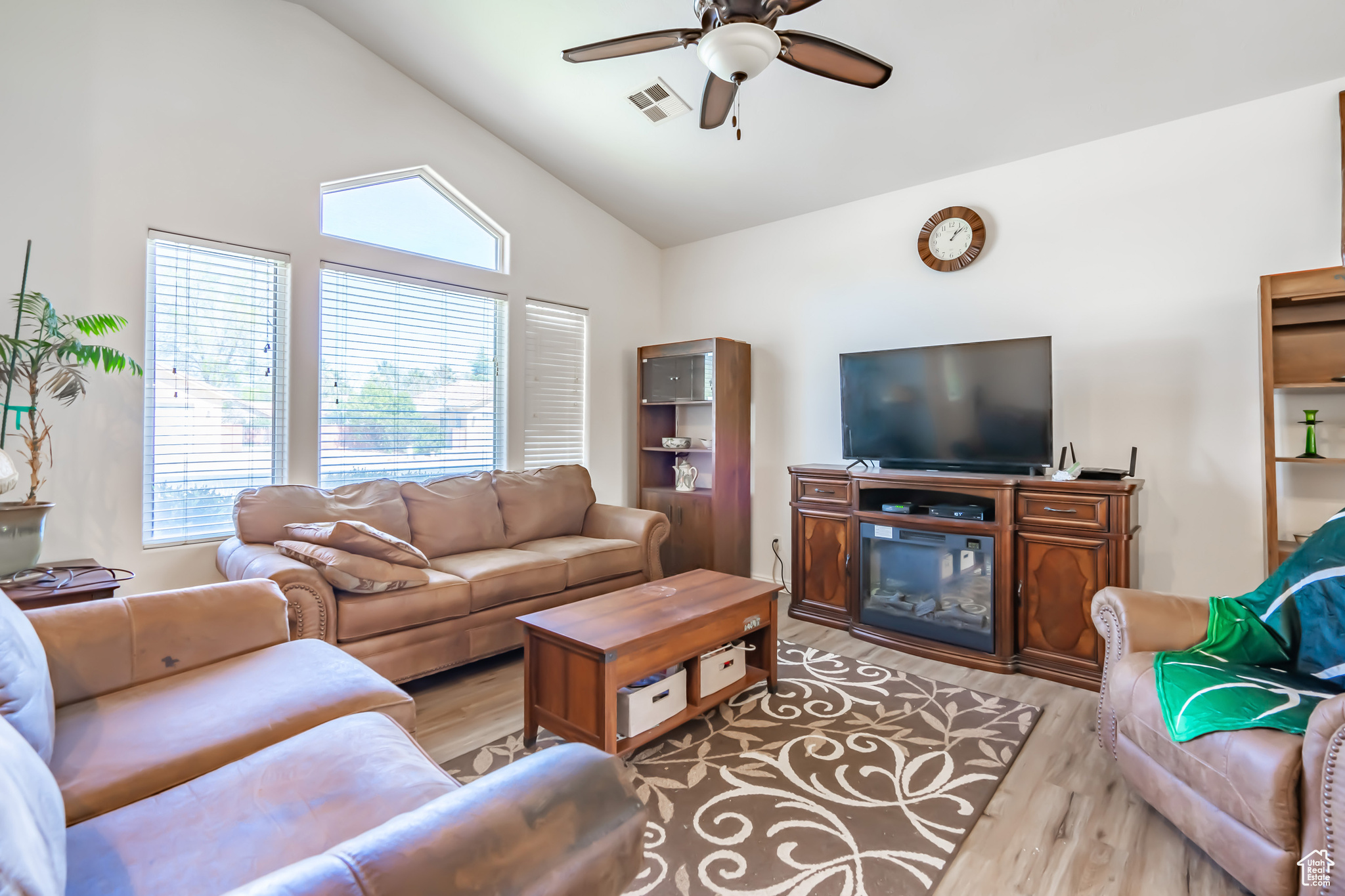 Living room with high vaulted ceiling, light hardwood / wood-style floors, and ceiling fan
