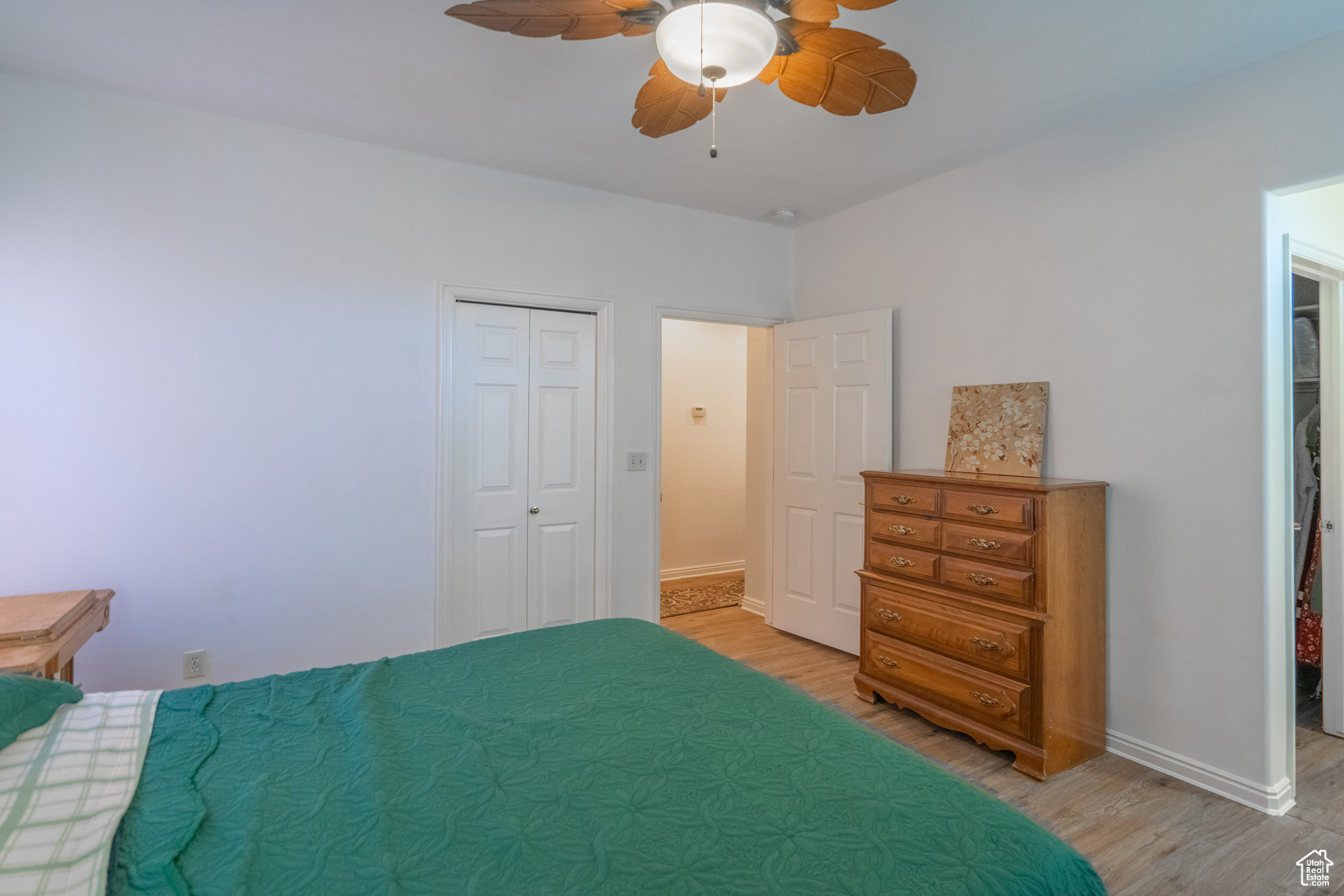 Bedroom with ceiling fan, a closet, and light wood-type flooring