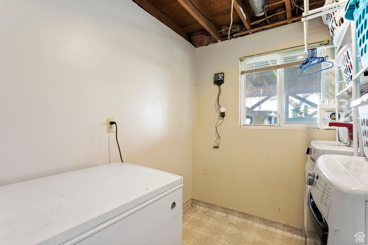 Laundry area featuring light tile floors and washer and clothes dryer