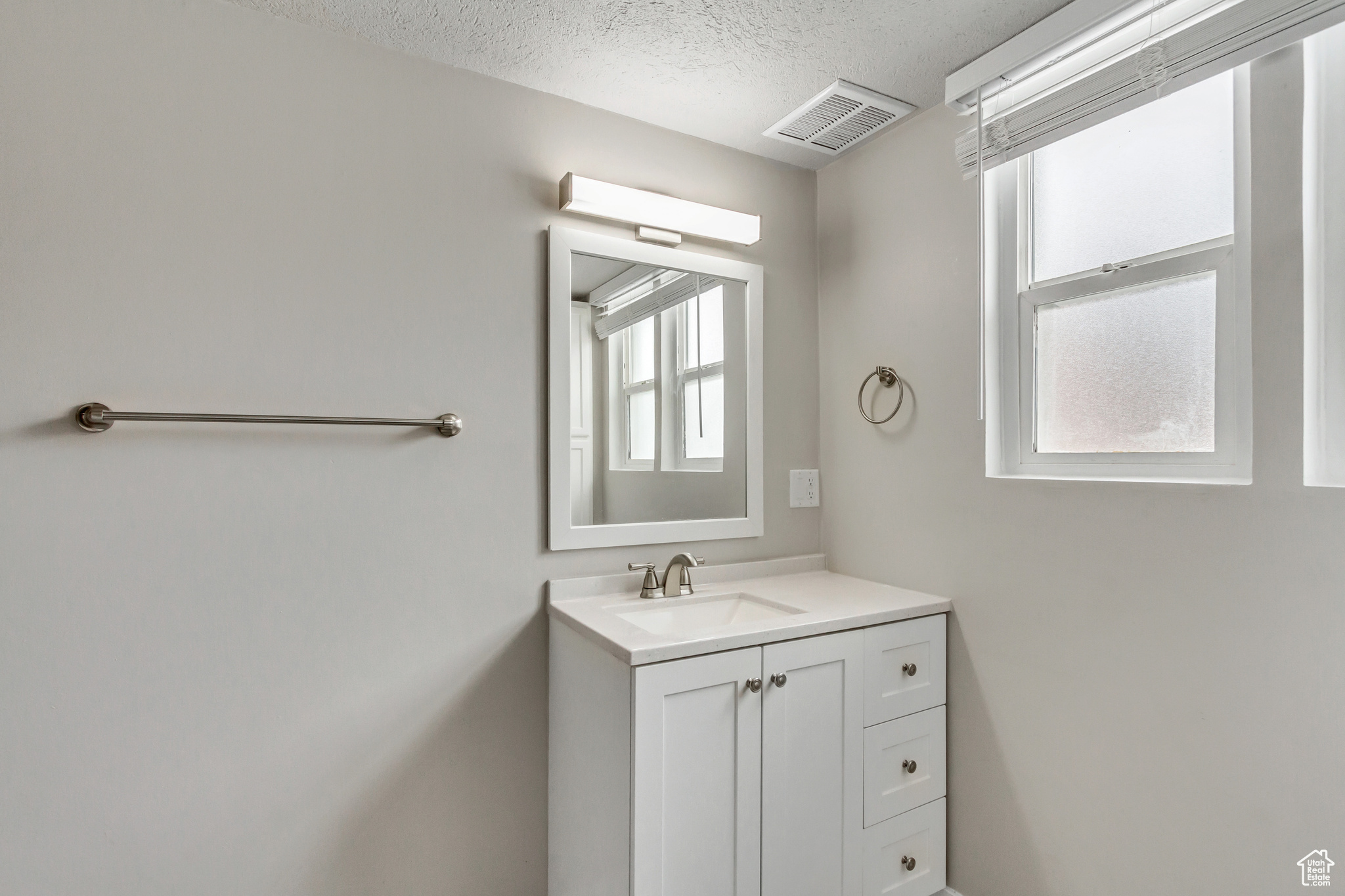 Bathroom featuring vanity and a textured ceiling