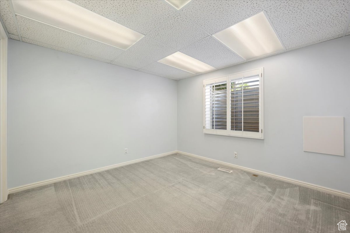 Carpeted spare room with a drop ceiling