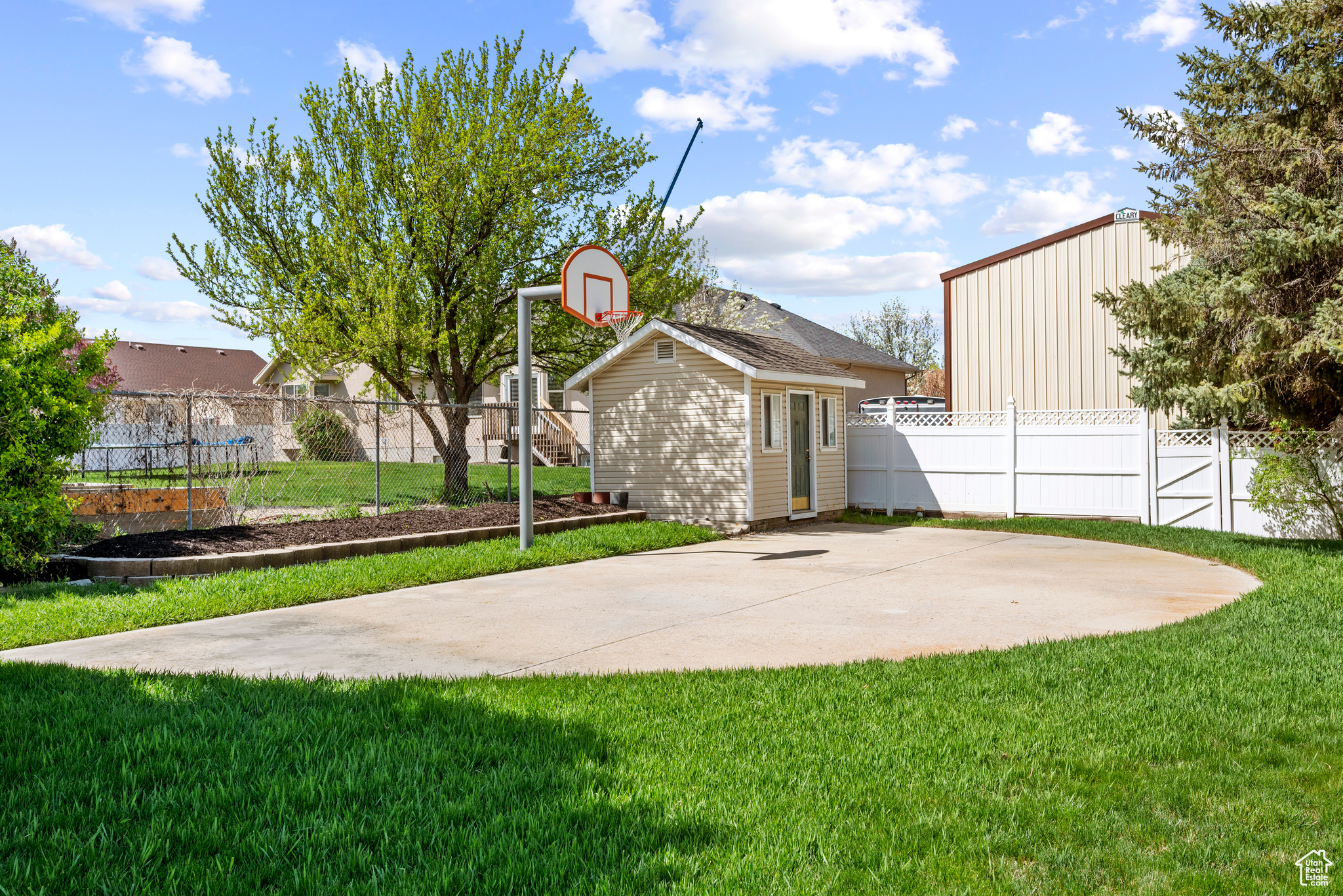View of yard with basketball court and storage shed