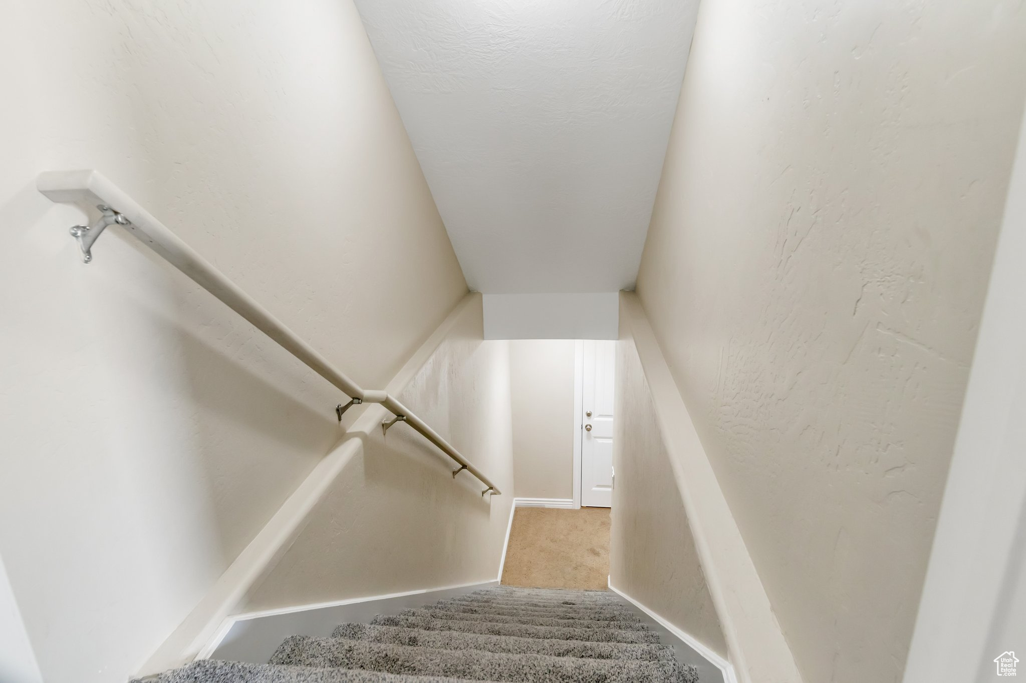 Stairs featuring light colored carpet
