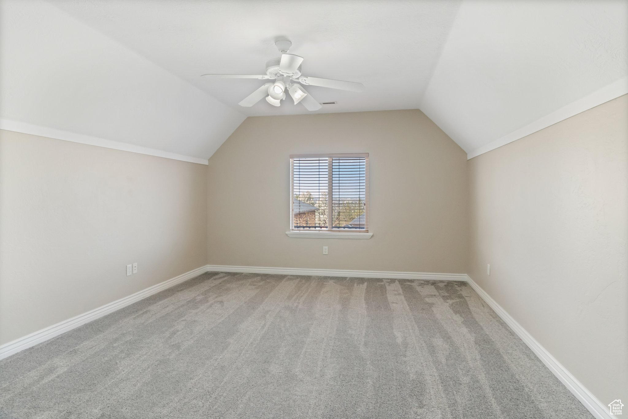 Additional living space featuring light colored carpet, ceiling fan, and lofted ceiling
